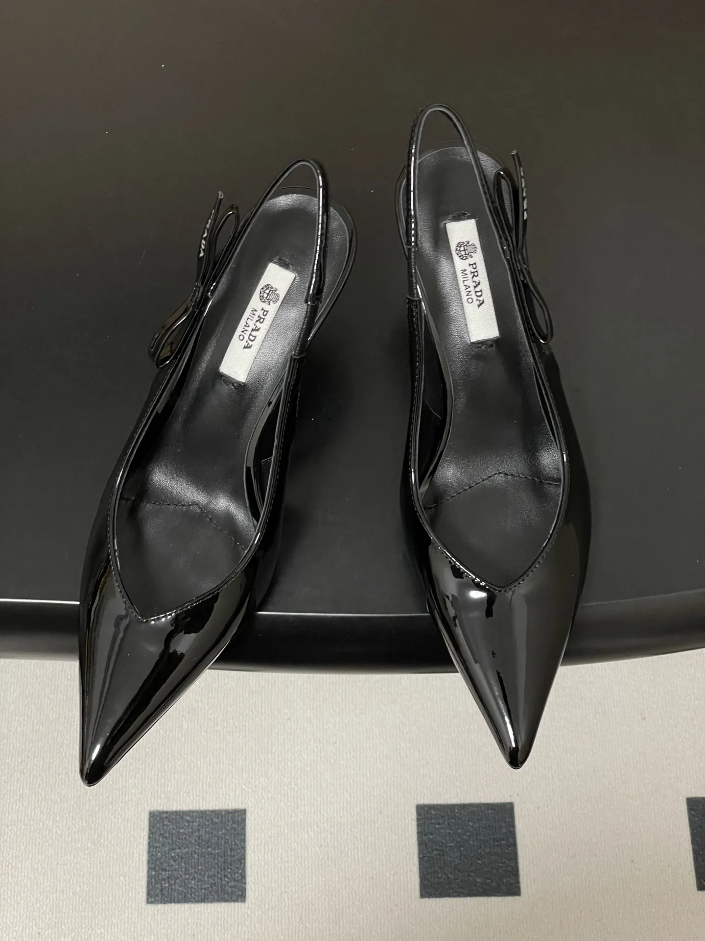p300-顶级品质（配高档飞机盒✈️） 26Ss春夏新款Prada 普拉达最新走秀款尖头蝴蝶结高跟鞋 复古老钱风露跟凉鞋 时尚界久违的极简之美 时髦又精致 日常穿出高级感 强烈的线条和大胆的细节将象征女性魅力的高跟鞋转变为独特而非传统的设计。尖头廓形采用牛皮革，具有明显的缝线和故意未完成的原始切割边缘。精致的细高跟完美呈现出此款鞋履的多面风格。 选用优质皮革材质，质感高级，呈现出复古又摩登的质感，工艺精细，体现品牌高端品质。细高跟设计，提升穿着者气场，同时保持了较好的稳定性，适合日常通勤或特殊场合穿着。 鞋面：牛漆皮/小羊皮/马毛 内里垫脚：羊皮 鞋底：意大利真皮大底 跟高：7.5cm 码数：35-39（40.41定做不退换）