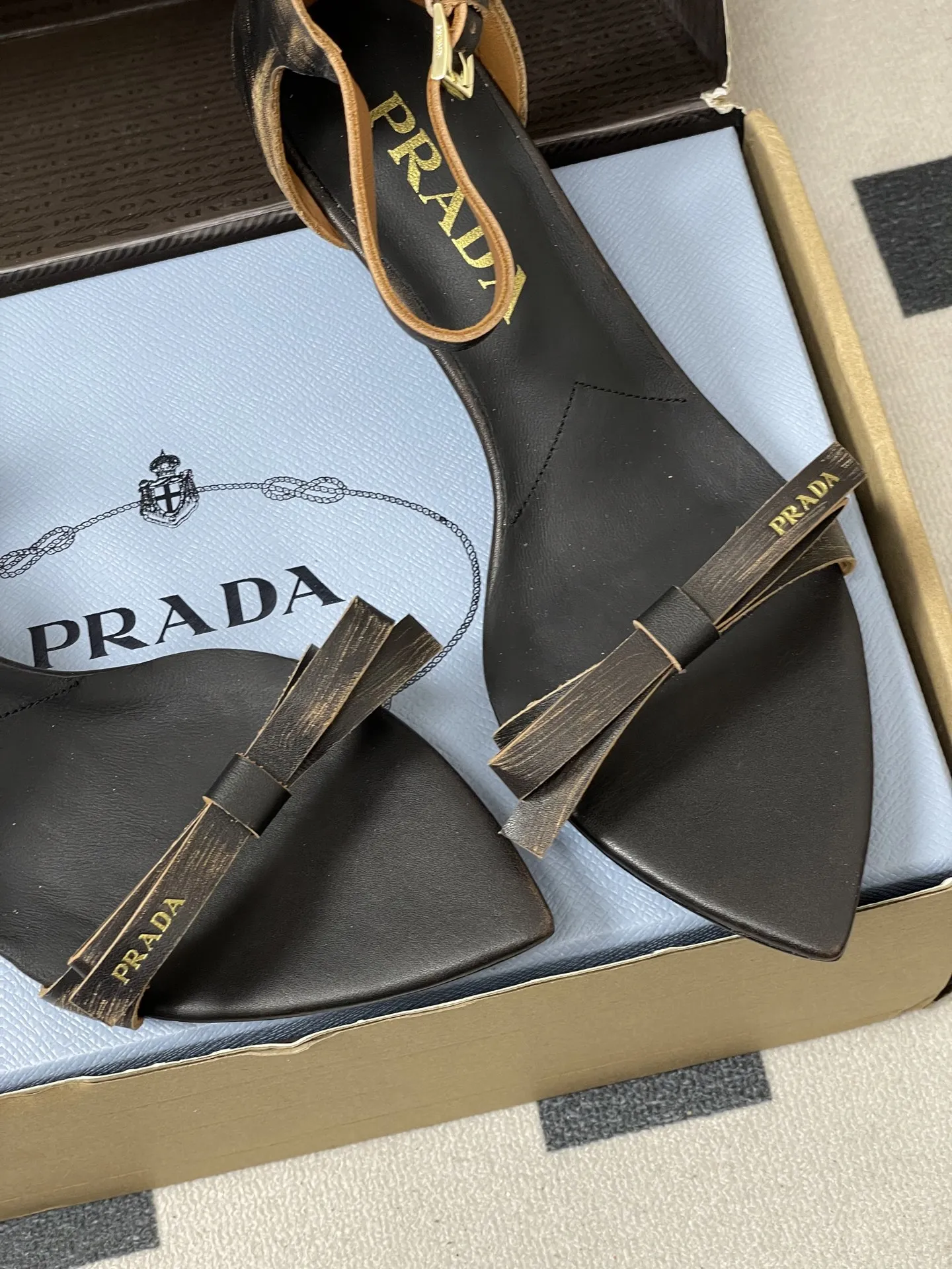 p340-顶级品质（配高档飞机盒✈️） 26Aw春夏新款Prada 普拉达走秀款尖头做旧蝴蝶结高跟凉鞋 复古老钱风露趾凉鞋 未来科技感满满 时尚界久违的极简之美 时髦又精致 日常穿出高级感 强烈的线条和大胆的细节将象征女性魅力的高跟鞋转变为独特而非传统的设计。尖头廓形采用做旧皮革，具有明显的缝线和故意未完成的原始切割边缘。精致的细高跟完美呈现出此款鞋履的多面风格。 选用优质皮革材质，质感高级，且有做旧效果的纹理，呈现出复古又摩登的质感，工艺精细，体现品牌高端品质。细高跟设计，提升穿着者气场，同时保持了较好的稳定性，适合日常通勤或特殊场合穿着。 鞋面：做旧小牛皮 内里垫脚：羊皮 鞋底：意大利注塑真皮大底 跟高：8.5cm/5.5cm 码数：35-39（40.41.42定做不退换）