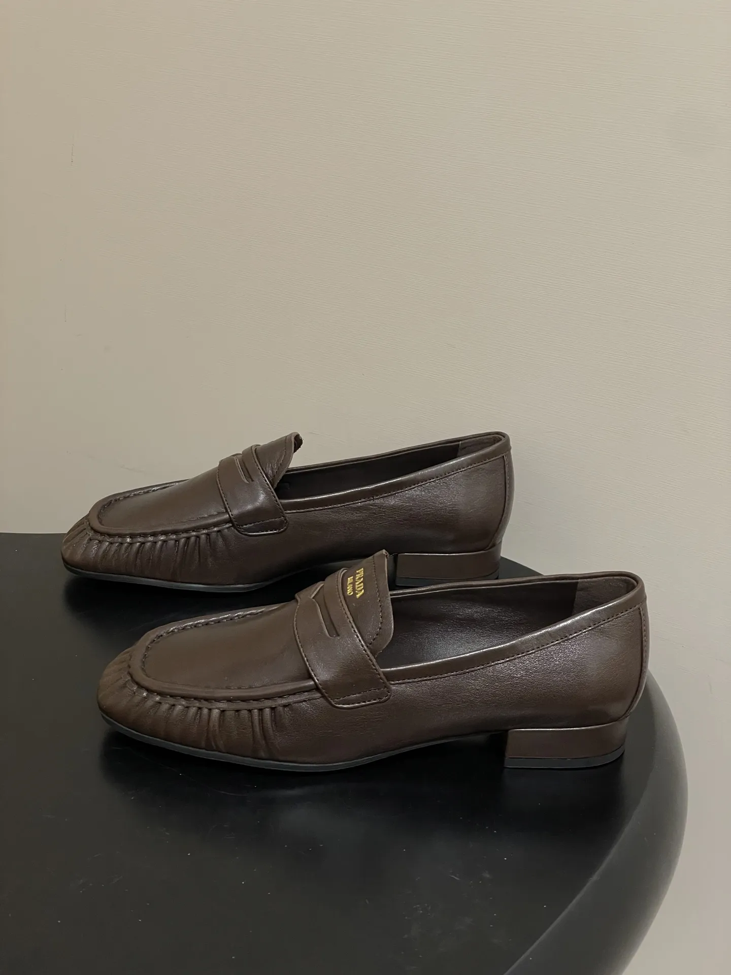 p310- 26Fw早春新款 Prada普拉达 褶皱一脚蹬乐福鞋老钱风麂皮单鞋 这款褶饰乐福鞋，选用优质皮革，柔软又耐用，鞋面褶皱设计超有辨识度!经典圆头+平底，日常通勤，休闲都能轻松驾驭。内衬和鞋垫都有PRADA标志，细节满分，低调又高级。百搭属性，无论牛仔裤还是裙装都能轻松hold住，是实用与时尚兼具的必备单品! 鞋面：油蜡小牛皮/高丝光牛反绒 内里垫脚：羊皮 鞋底：开模橡胶大底 码数：35-39（40.41定做不退换）