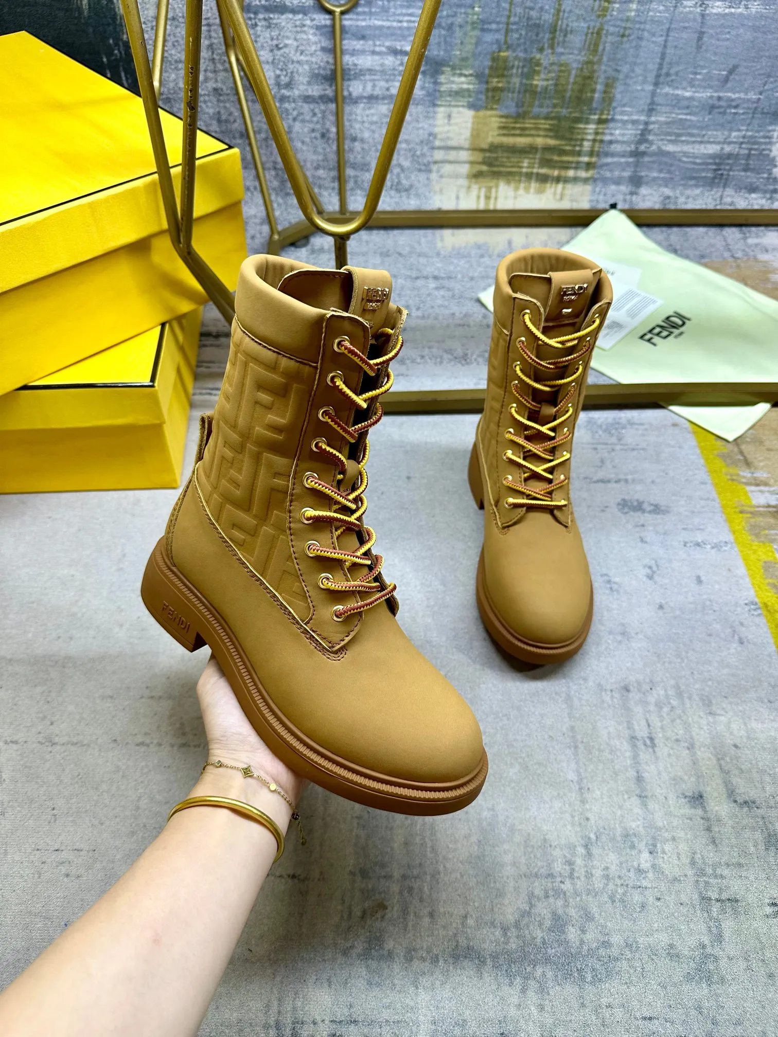 FENDI Filo圆头系带军靴。浅棕色防水绒面皮材质，饰有同色系标志性凸纹FF图案。双色登山鞋带开合，饰金属孔眼。背面饰有金色饰扣。橡胶鞋底，鞋跟侧面饰有FENDI字样。35-42码，P300