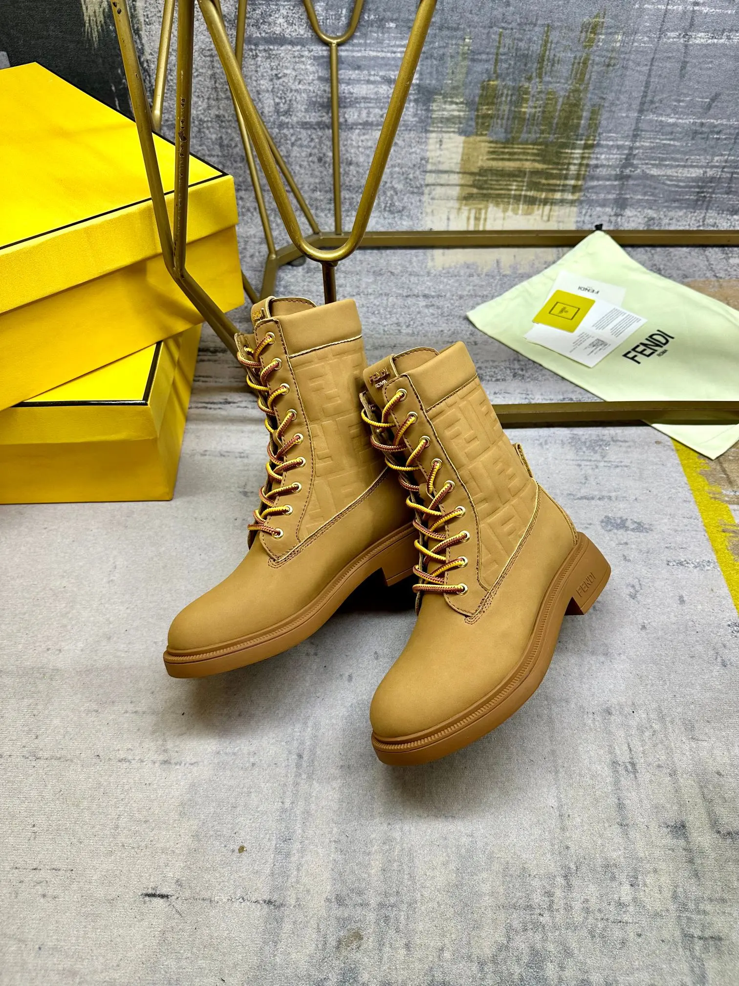 FENDI Filo圆头系带军靴。浅棕色防水绒面皮材质，饰有同色系标志性凸纹FF图案。双色登山鞋带开合，饰金属孔眼。背面饰有金色饰扣。橡胶鞋底，鞋跟侧面饰有FENDI字样。35-42码，P300