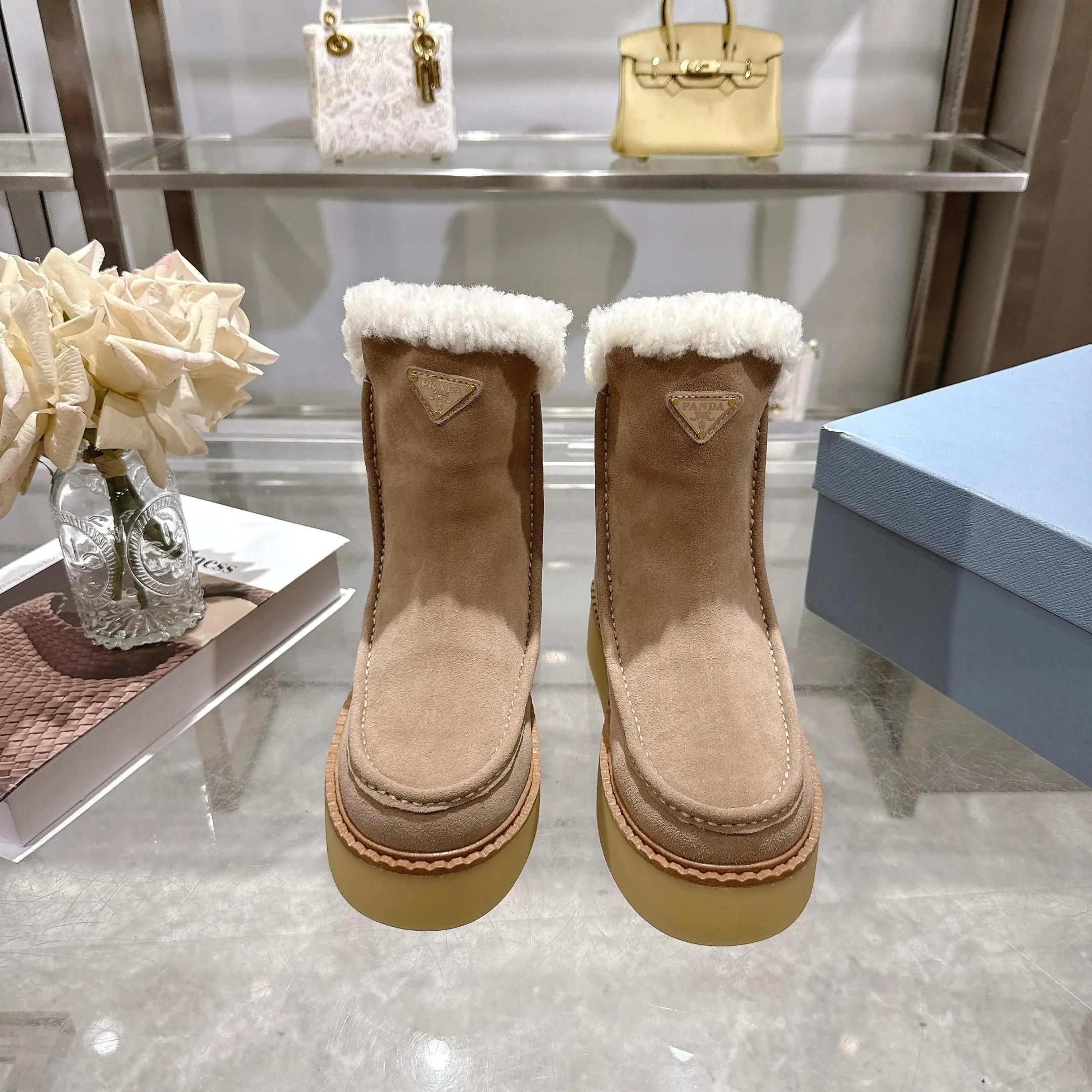 350!最新款普拉达,此款绒面牛皮革短靴结合橡胶厚底与柔软的羊皮毛衬里设计,勾勒利落线条,融入现代细节。 带衬里 涂珐琅三角形金属徽标 靴筒:14厘米 厚底,50毫米 凹凸纹1:1原版大底 凹口沿条 颜色:5 码数:35-42