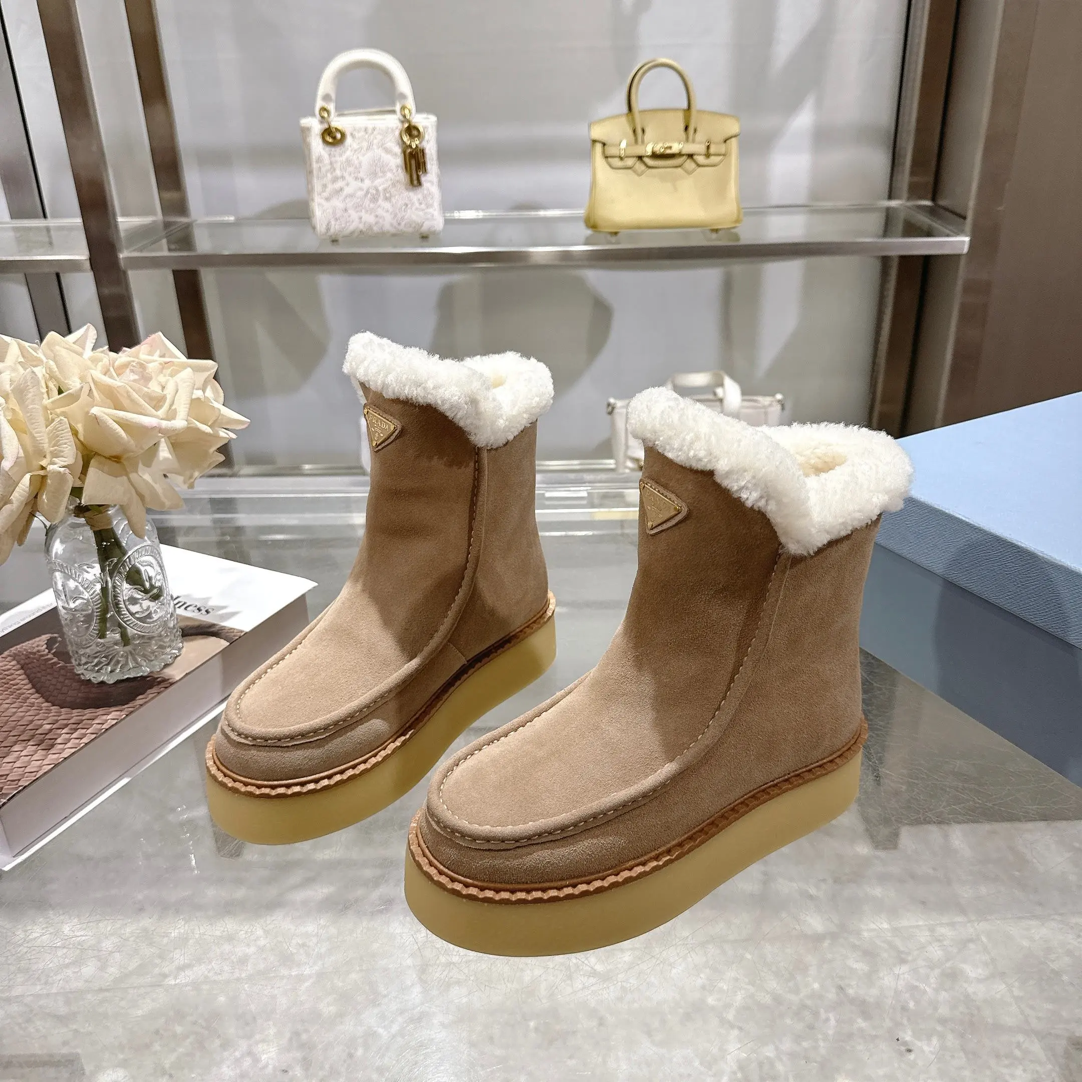 350!最新款普拉达,此款绒面牛皮革短靴结合橡胶厚底与柔软的羊皮毛衬里设计,勾勒利落线条,融入现代细节。 带衬里 涂珐琅三角形金属徽标 靴筒:14厘米 厚底,50毫米 凹凸纹1:1原版大底 凹口沿条 颜色:5 码数:35-42