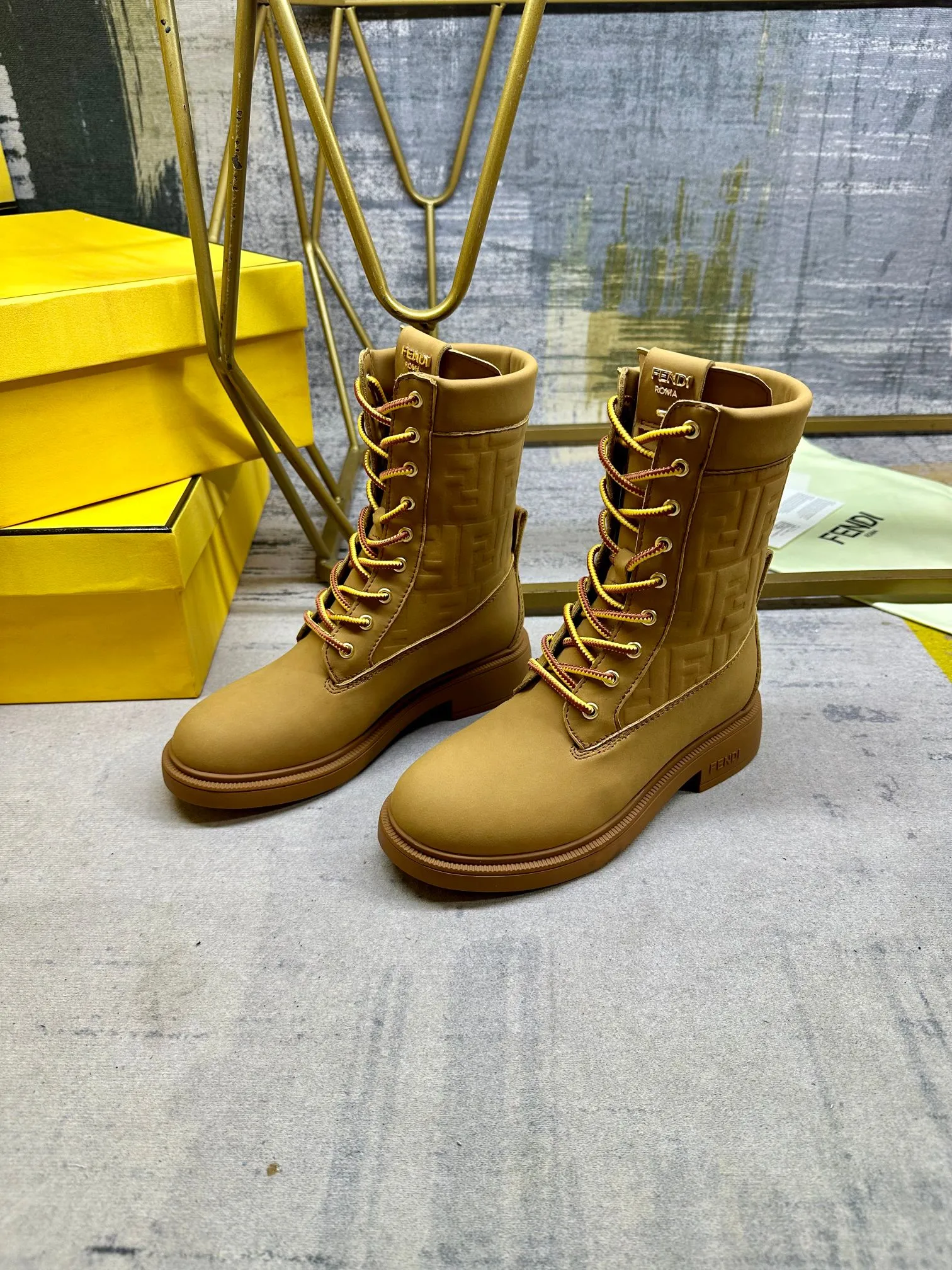 FENDI Filo圆头系带军靴。浅棕色防水绒面皮材质，饰有同色系标志性凸纹FF图案。双色登山鞋带开合，饰金属孔眼。背面饰有金色饰扣。橡胶鞋底，鞋跟侧面饰有FENDI字样。35-42码，P300