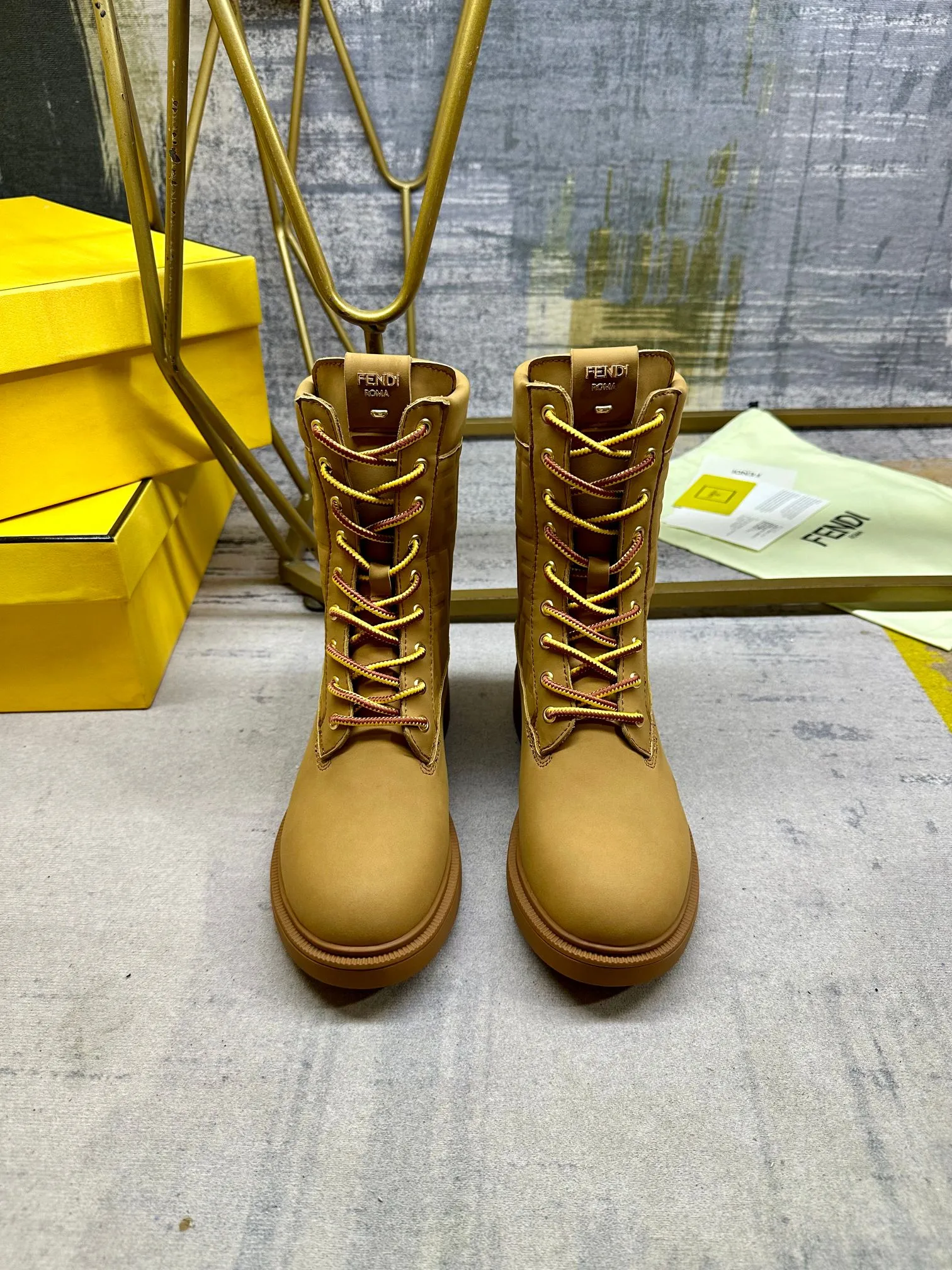 FENDI Filo圆头系带军靴。浅棕色防水绒面皮材质，饰有同色系标志性凸纹FF图案。双色登山鞋带开合，饰金属孔眼。背面饰有金色饰扣。橡胶鞋底，鞋跟侧面饰有FENDI字样。35-42码，P300