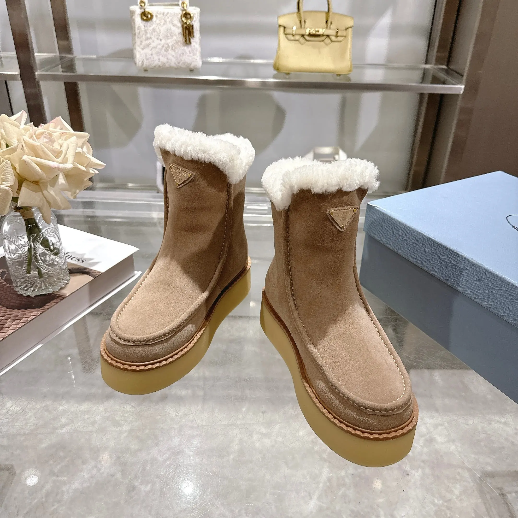 350!最新款普拉达,此款绒面牛皮革短靴结合橡胶厚底与柔软的羊皮毛衬里设计,勾勒利落线条,融入现代细节。 带衬里 涂珐琅三角形金属徽标 靴筒:14厘米 厚底,50毫米 凹凸纹1:1原版大底 凹口沿条 颜色:5 码数:35-42