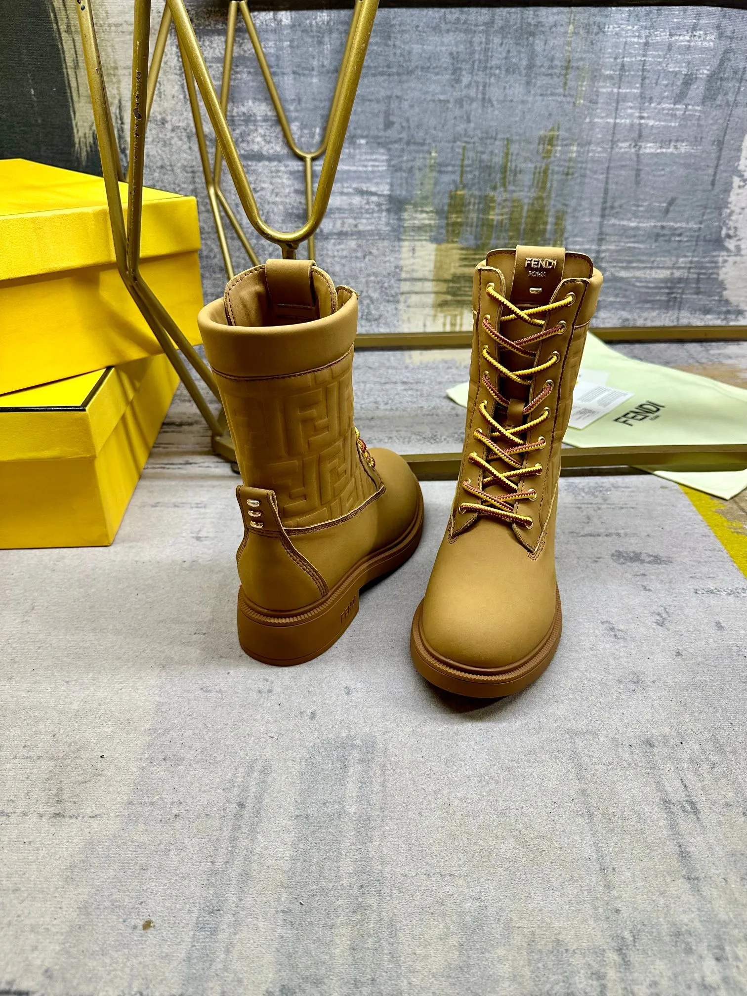 FENDI Filo圆头系带军靴。浅棕色防水绒面皮材质，饰有同色系标志性凸纹FF图案。双色登山鞋带开合，饰金属孔眼。背面饰有金色饰扣。橡胶鞋底，鞋跟侧面饰有FENDI字样。35-42码，P300