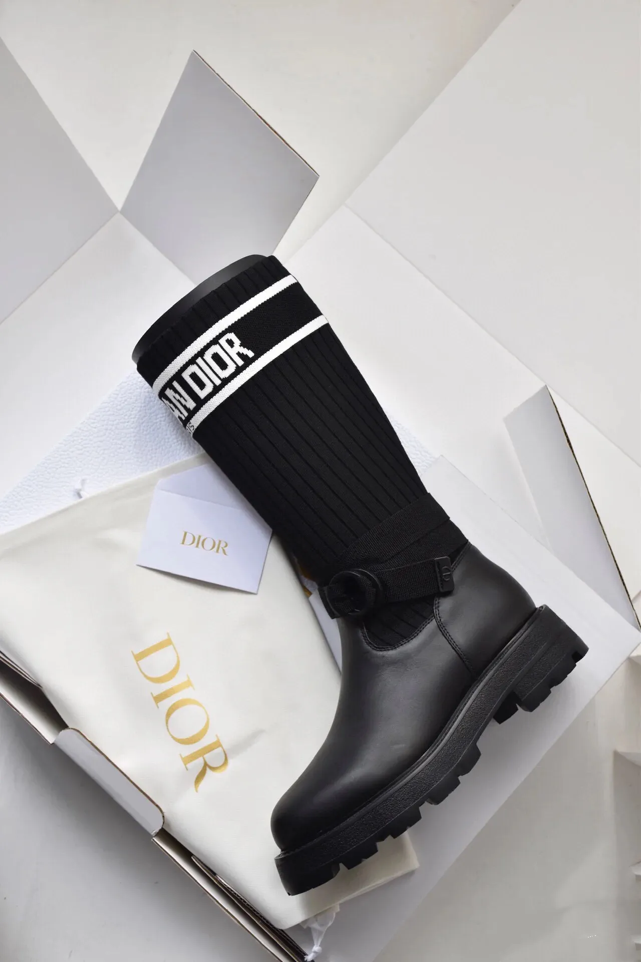 橙子出厂价💰160 Dior 迪奥 弹力袜靴 💫 神仙设计点 ▫️皮革靴头+弹力针织袜筒的碰撞太绝了 靴筒像压力袜一样包裹小腿 却完全不勒肉 皮革部分支撑力超好 走路带风也不变形 ▫️最心机的是袜筒上的白色织带字母 “CHRISTIAN DIOR PARIS”直接点亮全身 ▫️工装风搭扣+5cm隐形厚底 小个子狂喜 视觉增高10cm不说 还自带复古街头感 💡真实体验: • 针织部分弹性超大 肌肉腿友好 • 厚底走路超稳 逛街暴走无压力 • 织带是立体刺绣的 洗了也不掉色 • 重点是真的显腿直!从脚踝到膝盖的包裹绝了 Size:35-40 现货发售!