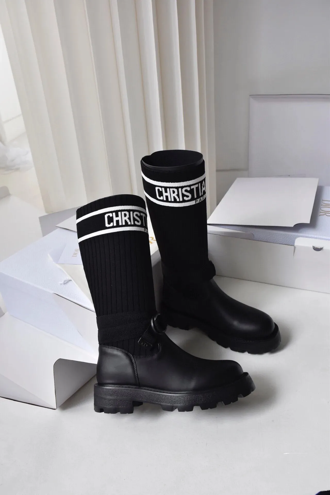 橙子出厂价💰160 Dior 迪奥 弹力袜靴 💫 神仙设计点 ▫️皮革靴头+弹力针织袜筒的碰撞太绝了 靴筒像压力袜一样包裹小腿 却完全不勒肉 皮革部分支撑力超好 走路带风也不变形 ▫️最心机的是袜筒上的白色织带字母 &ldquo;CHRISTIAN DIOR PARIS&rdquo;直接点亮全身 ▫️工装风搭扣+5cm隐形厚底 小个子狂喜 视觉增高10cm不说 还自带复古街头感 💡真实体验： &bull; 针织部分弹性超大 肌肉腿友好 &bull; 厚底走路超稳 逛街暴走无压力 &bull; 织带是立体刺绣的 洗了也不掉色 &bull; 重点是真的显腿直！从脚踝到膝盖的包裹绝了 Size:35-40 现货发售！