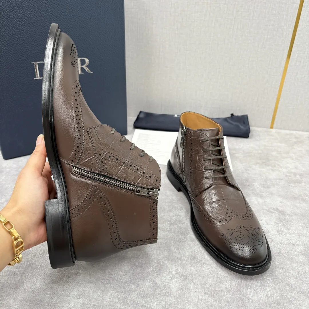 CD家新品 Dior 迪-奥 男士布洛克短靴 中帮皮靴 法式奢华与英伦雅痞的跨界杰作 高定基因邂逅布洛克雕花的复古风情，这系列男士短靴便成为了时尚界&ldquo;雅痞绅士&rdquo;的风格符号。选用顶级小牛皮/开边珠亮皮，部分鞋款采用鳄鱼纹压花工艺，光泽度饱满且富有层次 。经典布洛克雕花工艺贯穿鞋身，精致的冲孔与纹路如艺术品般细腻，是英伦复古风的标志性表达；侧边拉链设计暗藏巧思，既保证了穿脱的便捷性，又让鞋面线条保持简洁流畅；内里采用亲肤性极佳的小牛皮质衬里，行走时的舒适感拉满。采用意大利真皮大底复合橡胶底片。 短靴廓形利落干练，贴合脚踝的剪裁既保留了靴子的飒爽型格，又能完美适配西裤、牛仔裤等多种穿搭，打造&ldquo;一鞋多搭&rdquo;的时尚可能性。配原包装发售！！！ 标准皮鞋码数：39-44 （38.4546定做） 💰570&yen;