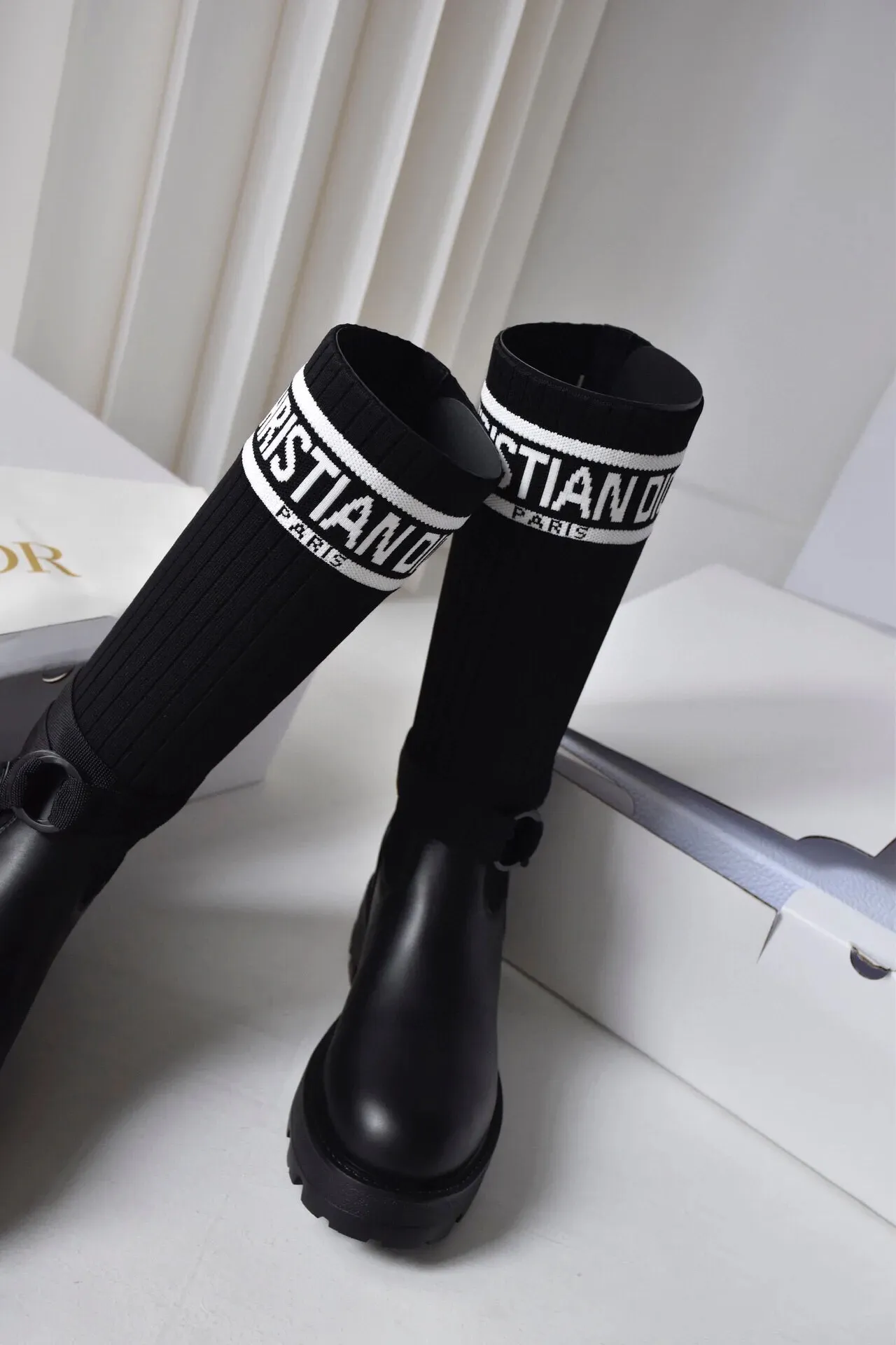 橙子出厂价💰160 Dior 迪奥 弹力袜靴 💫 神仙设计点 ▫️皮革靴头+弹力针织袜筒的碰撞太绝了 靴筒像压力袜一样包裹小腿 却完全不勒肉 皮革部分支撑力超好 走路带风也不变形 ▫️最心机的是袜筒上的白色织带字母 “CHRISTIAN DIOR PARIS”直接点亮全身 ▫️工装风搭扣+5cm隐形厚底 小个子狂喜 视觉增高10cm不说 还自带复古街头感 💡真实体验: • 针织部分弹性超大 肌肉腿友好 • 厚底走路超稳 逛街暴走无压力 • 织带是立体刺绣的 洗了也不掉色 • 重点是真的显腿直!从脚踝到膝盖的包裹绝了 Size:35-40 现货发售!