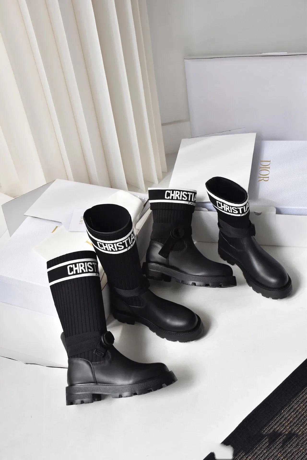 橙子出厂价💰160 Dior 迪奥 弹力袜靴 💫 神仙设计点 ▫️皮革靴头+弹力针织袜筒的碰撞太绝了 靴筒像压力袜一样包裹小腿 却完全不勒肉 皮革部分支撑力超好 走路带风也不变形 ▫️最心机的是袜筒上的白色织带字母 “CHRISTIAN DIOR PARIS”直接点亮全身 ▫️工装风搭扣+5cm隐形厚底 小个子狂喜 视觉增高10cm不说 还自带复古街头感 💡真实体验: • 针织部分弹性超大 肌肉腿友好 • 厚底走路超稳 逛街暴走无压力 • 织带是立体刺绣的 洗了也不掉色 • 重点是真的显腿直!从脚踝到膝盖的包裹绝了 Size:35-40 现货发售!