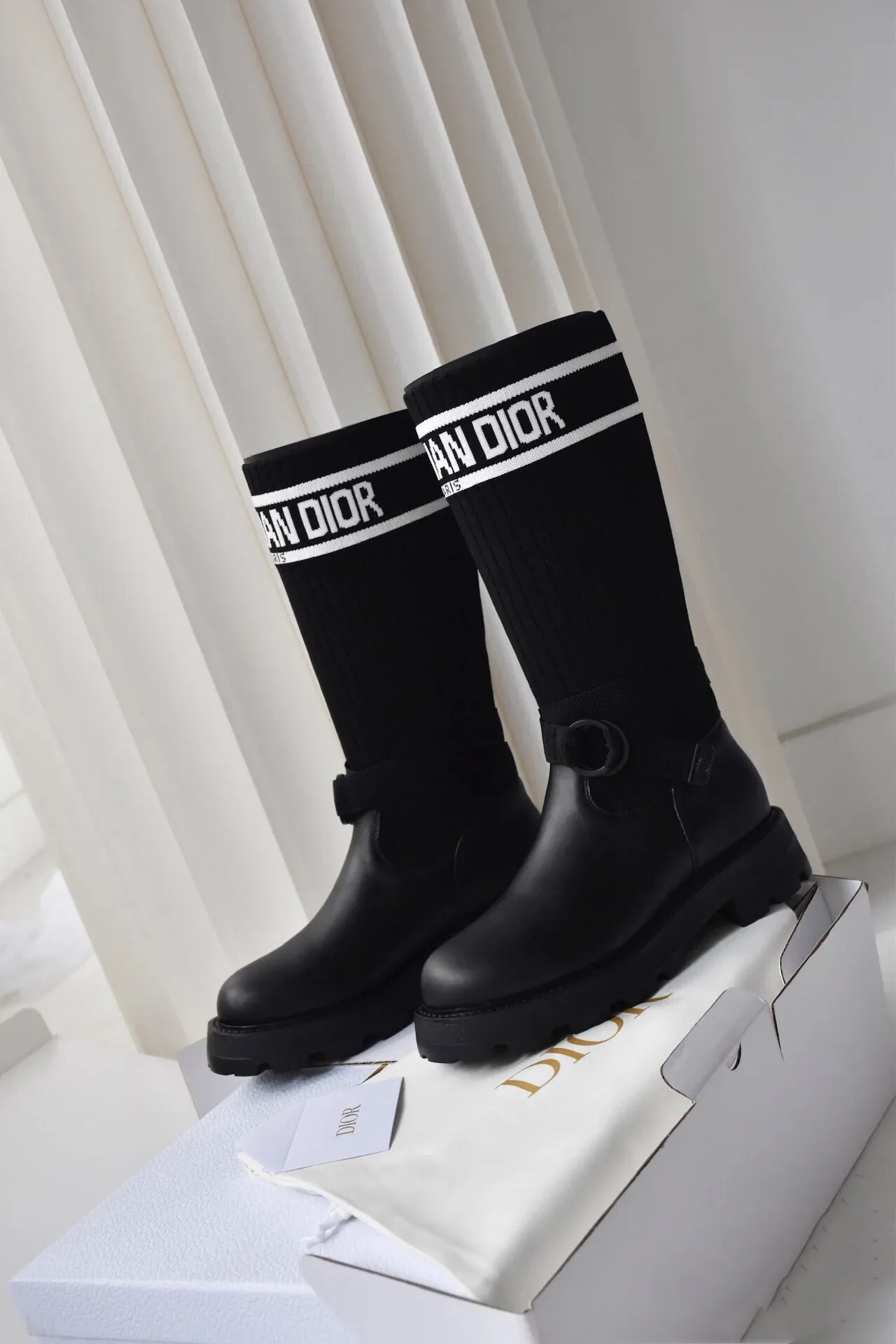 橙子出厂价💰160 Dior 迪奥 弹力袜靴 💫 神仙设计点 ▫️皮革靴头+弹力针织袜筒的碰撞太绝了 靴筒像压力袜一样包裹小腿 却完全不勒肉 皮革部分支撑力超好 走路带风也不变形 ▫️最心机的是袜筒上的白色织带字母 “CHRISTIAN DIOR PARIS”直接点亮全身 ▫️工装风搭扣+5cm隐形厚底 小个子狂喜 视觉增高10cm不说 还自带复古街头感 💡真实体验: • 针织部分弹性超大 肌肉腿友好 • 厚底走路超稳 逛街暴走无压力 • 织带是立体刺绣的 洗了也不掉色 • 重点是真的显腿直!从脚踝到膝盖的包裹绝了 Size:35-40 现货发售!