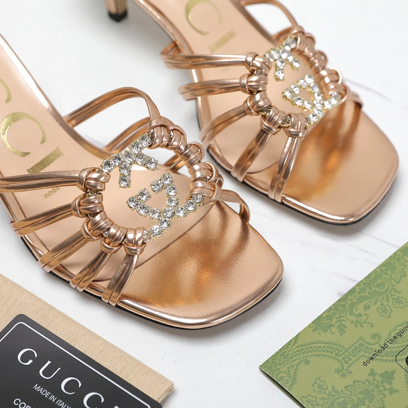 🔥🔥🔥💯💯💯GUCCi高端精品 拖鞋2025古驰早春系列😍GG水晶缀饰钻扣编织带凉鞋🔥顶级🆙代购品质！原版1:1复刻，毎个细节皆经过精心打磨细腻制作.可与ZG对比如一，无二品质！ 这款编织带凉鞋由饰闪亮GG水晶金色互扣式双G五金扣点缀细带精致笼形鞋面制作而成，尽显天马行空风范，富有优雅女性魅力细节展现女性气质的理念，打造令人惊艳的作品👏👏焕新演绎！ 面料：原版定制进口金属皮 内里/垫脚：进口羊皮里 鞋跟：4.5cm/9cm 大底：意大利真皮底 尺码：35-42（41 42定做不退换） 包装：全套绿色原包装。 跑量价：拖鞋260💰 凉鞋270💰