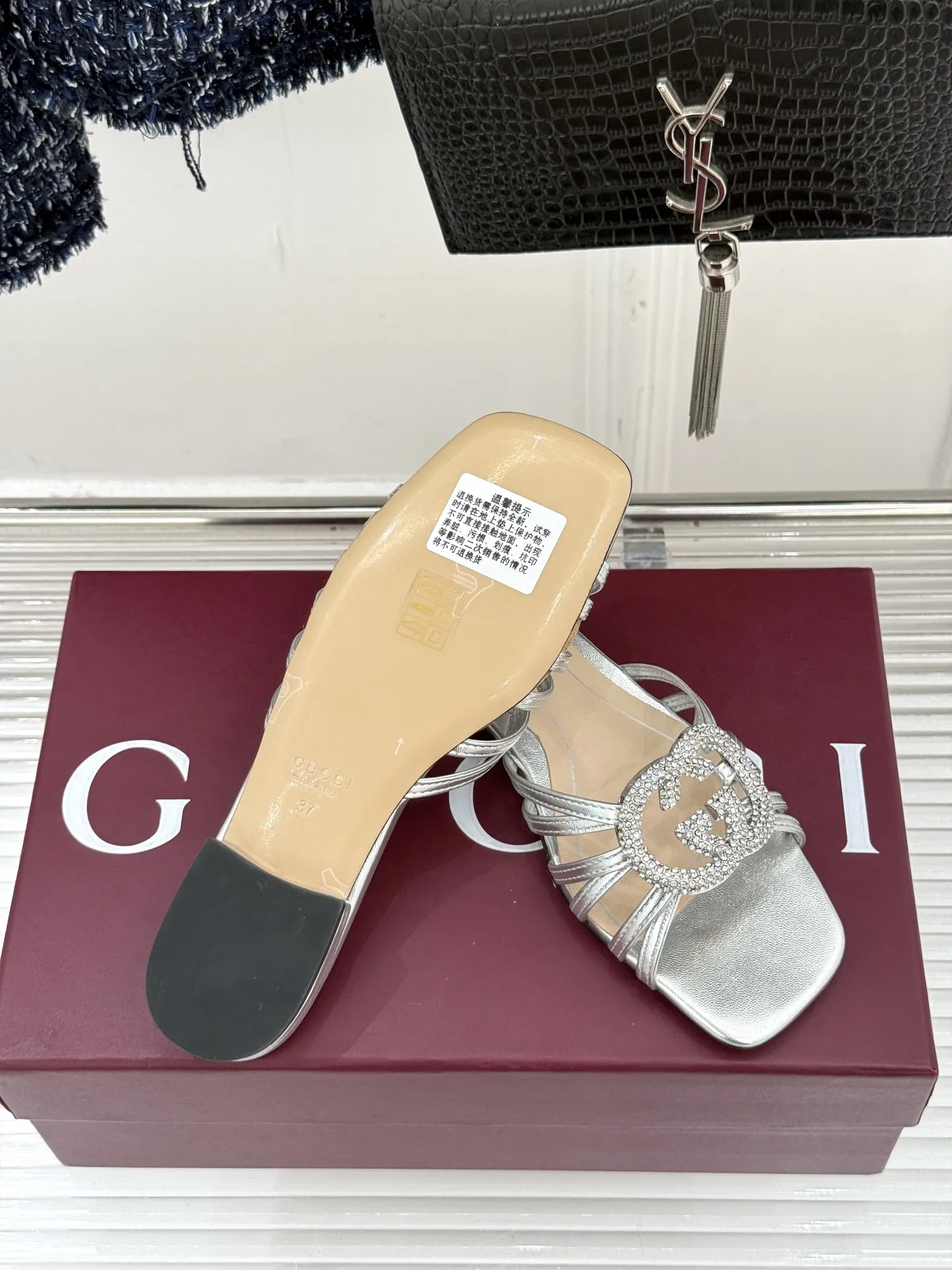 厂价💰240 Gucci/古驰25WF早春水钻双G细带 平底高跟拖鞋 以经典符号与璀璨钻光重构早春格调 将意式“不经意的优雅”融入鞋履方寸 步履间尽显奢品质感与摩登张力。 鞋身核心缀立体金属双G标识 满镶细碎水钻 光线折射下闪映莹润光泽 不浮夸却自带高光辨识度 既是品牌百年DNA的当代转译 百搭属性适配全场景穿搭 搭配真丝吊带裙 是约会通勤的温柔奢雅 配高腰阔腿裤与简约衬衫 干练摩登格调 搭碎花茶歇裙 适配早春度假出行 轻松成为造型点睛之笔 昼夜切换造型皆得体出众。 面料采用原版定制皮料 内里踮脚均为羊皮 意大利进口真皮大底 size:35-39(40/41/42定制)