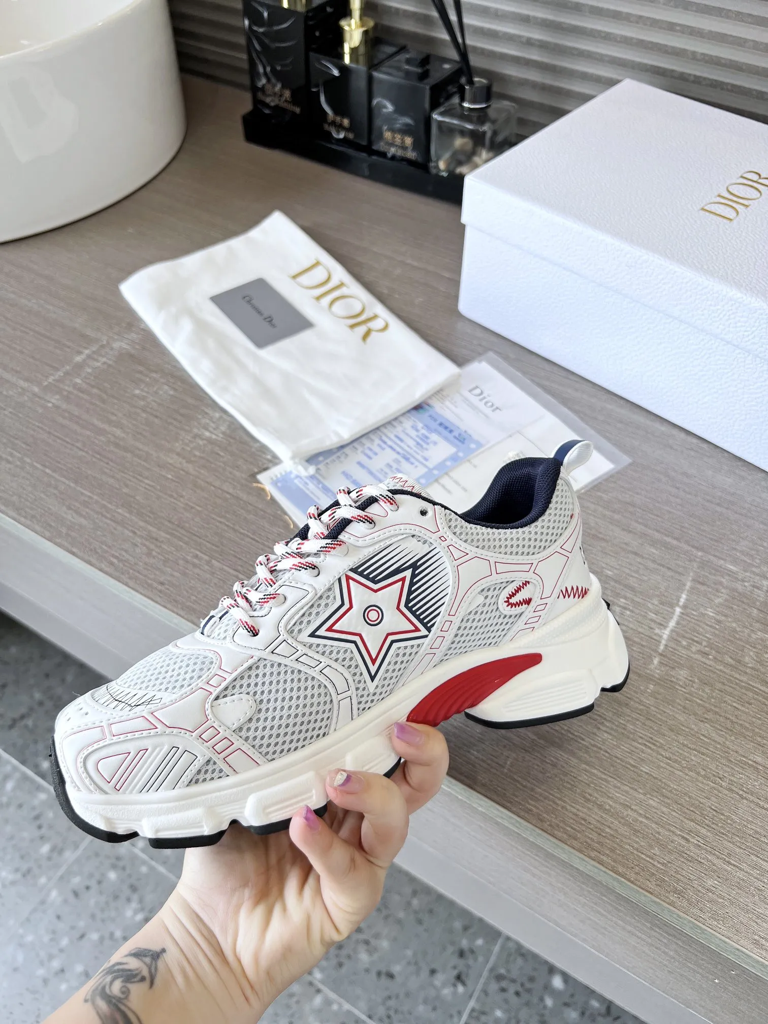 这款 Dior Chrono 运动鞋是二零二四秋季新品,以 Dior 的高订风格重新演绎跑步鞋。白色网眼织物搭配红色和白色调层压皮革效果镶片,两侧的 CD 标志、鞋舌上的星星补丁和鞋跟的 Dior 标志,诸多细节彰显格调。采用双色鞋带,轻盈鞋底搭配星星装饰,可全年打造休闲造型。 价格:P250 码数:女码35-41(35/42可定做) 男码40-46 颜色:白、全白、粉、金、银、红