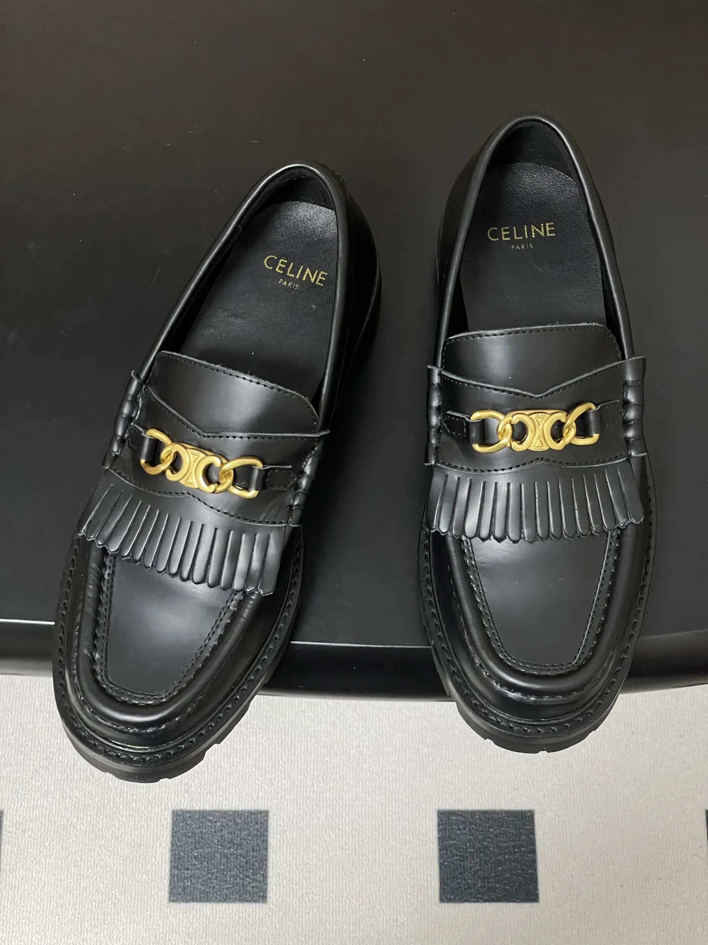 p310-顶级品质 26Fw春夏新款 CELINE 赛琳/思琳 经典凯旋门金属扣乐福鞋流苏吊坠一脚蹬厚底小皮鞋 鞋身点缀凯旋门金属扣/金属流苏,部分款还有金属饰牌,轻奢辨识度拉满。厚底+乐福鞋型,“一脚蹬”穿脱方便,厚底既增高又比细跟更稳;方头设计修饰脚型,不挤脚趾。 采用亮面/哑光皮革,质感细腻耐用;部分款加入流苏、缝线等复古元素,风格更丰富。属于“百搭款”搭西装是通勤精英风,搭牛仔裤是松弛休闲感,棕/黑/焦糖色等配色适配不同穿搭场景。 鞋面:定制牛皮 内里垫脚:牛皮 鞋底:真皮沿条/原版私模进口材质多层组合大底 跟高:3cm 码数:35-39(40.41定做不退换)