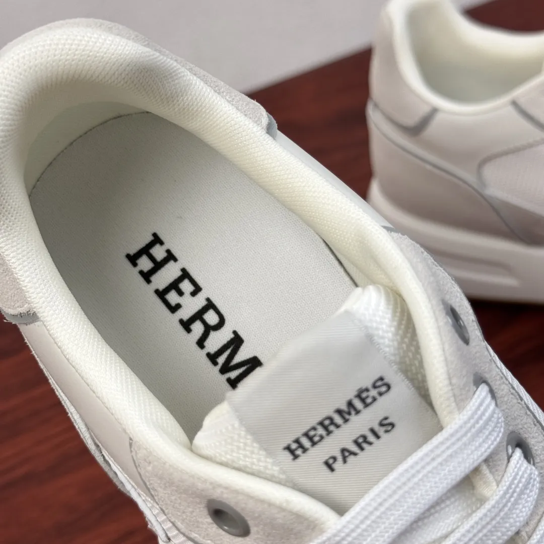 批380 Hermes/爱马仕 Match系列运动鞋 新款出货！复古休闲运动鞋｜意式匠艺与法式优雅的碰撞！鞋面甄选细腻粒面小牛皮与柔软麂皮，搭配透气网布拼接，层次丰富且质感高级，每一处缝线都彰显手工匠艺。标志性立体&ldquo;H&rdquo;字母缀饰，既是品牌辨识度的体现，也是复古美学的点睛之笔。轻量化橡胶大底搭配缓震中底，行走时柔韧回弹，久穿不累。经典系带设计贴合脚型，多色可选适配不同穿搭场景，无论是商务通勤还是休闲出街，都能轻松驾驭。多重款式可选，满足不同场景搭配需求，全套包装！ 尺码：39-40-41-43-43-44皮鞋尺码（可定制38.45） 货号：H1211反绒布 白色