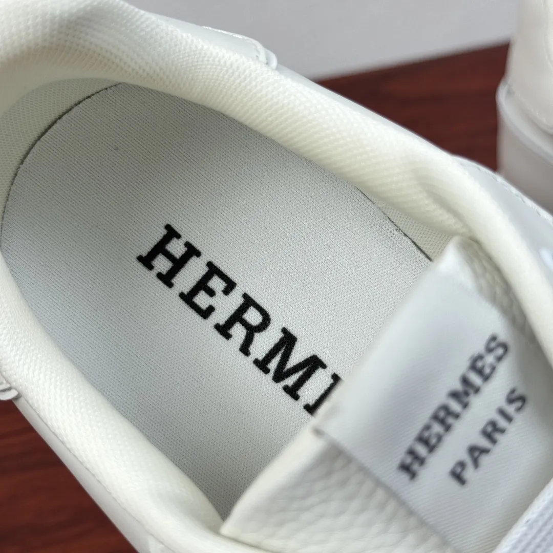 批380 Hermes/爱马仕 Match系列运动鞋 新款出货！复古休闲运动鞋｜意式匠艺与法式优雅的碰撞！鞋面甄选细腻粒面小牛皮与柔软麂皮，搭配透气网布拼接，层次丰富且质感高级，每一处缝线都彰显手工匠艺。标志性立体&ldquo;H&rdquo;字母缀饰，既是品牌辨识度的体现，也是复古美学的点睛之笔。轻量化橡胶大底搭配缓震中底，行走时柔韧回弹，久穿不累。经典系带设计贴合脚型，多色可选适配不同穿搭场景，无论是商务通勤还是休闲出街，都能轻松驾驭。多重款式可选，满足不同场景搭配需求，全套包装！ 尺码：39-40-41-43-43-44皮鞋尺码（可定制38.45） 货号：H1211全皮 白色