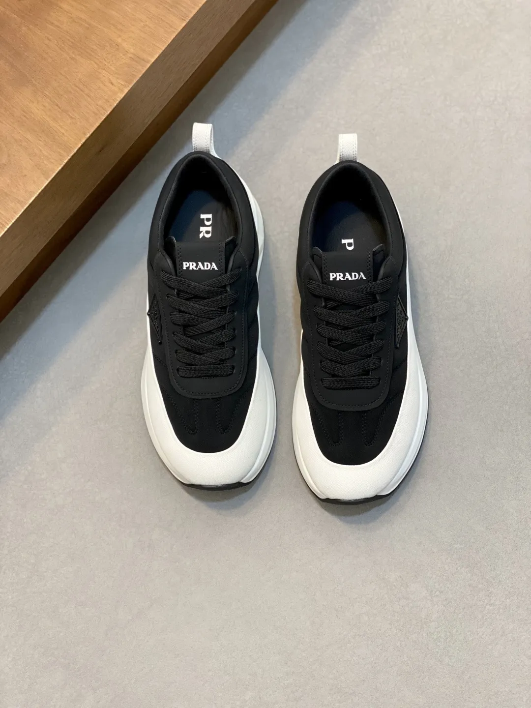 💰380 Prada/普拉达 男士新款皮面拼接运动鞋 这款运动鞋呈现现代版型,以利落线条与流畅细节重新演绎品牌典藏款型。鞋履采用小牛皮革和科技织物打造,外侧饰有三角金属徽标,后跟亮色TPU装饰,内里后跟加长加衬设计,穿着更舒适,鞋舌饰有丝印徽标,搭配后跟镂空橡胶厚底,全牛皮内里标配徽标牛皮垫脚,上脚增高舒适、百搭耐看!配全套原包装! 码数:39-40-41-42-43-44 标准皮鞋尺码(45可定做不支持退换)