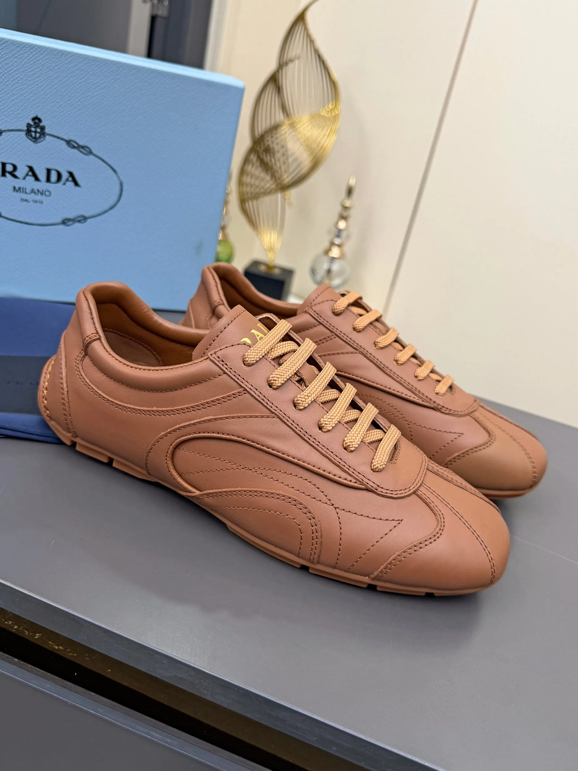 实价不让利P300！普拉达&middot;PRADA🔥2026最新款休闲德训鞋⛳️原版1比1开发，复古时髦前卫的设计，让整双鞋轻便舒适，皮与高丝光牛绒的设计更是简洁大方，搭配古沙滩凉鞋造型，每一个元素都踩在时髦点上🤗 ✦面料：进口头层牛皮 ✦内里：羊皮内里 ✦大底：原版1:1开双色生胶底 ✦码数：女码 35--40， ✦码数：男码 39--44， ✦码数：可以定做女41 女42 男45