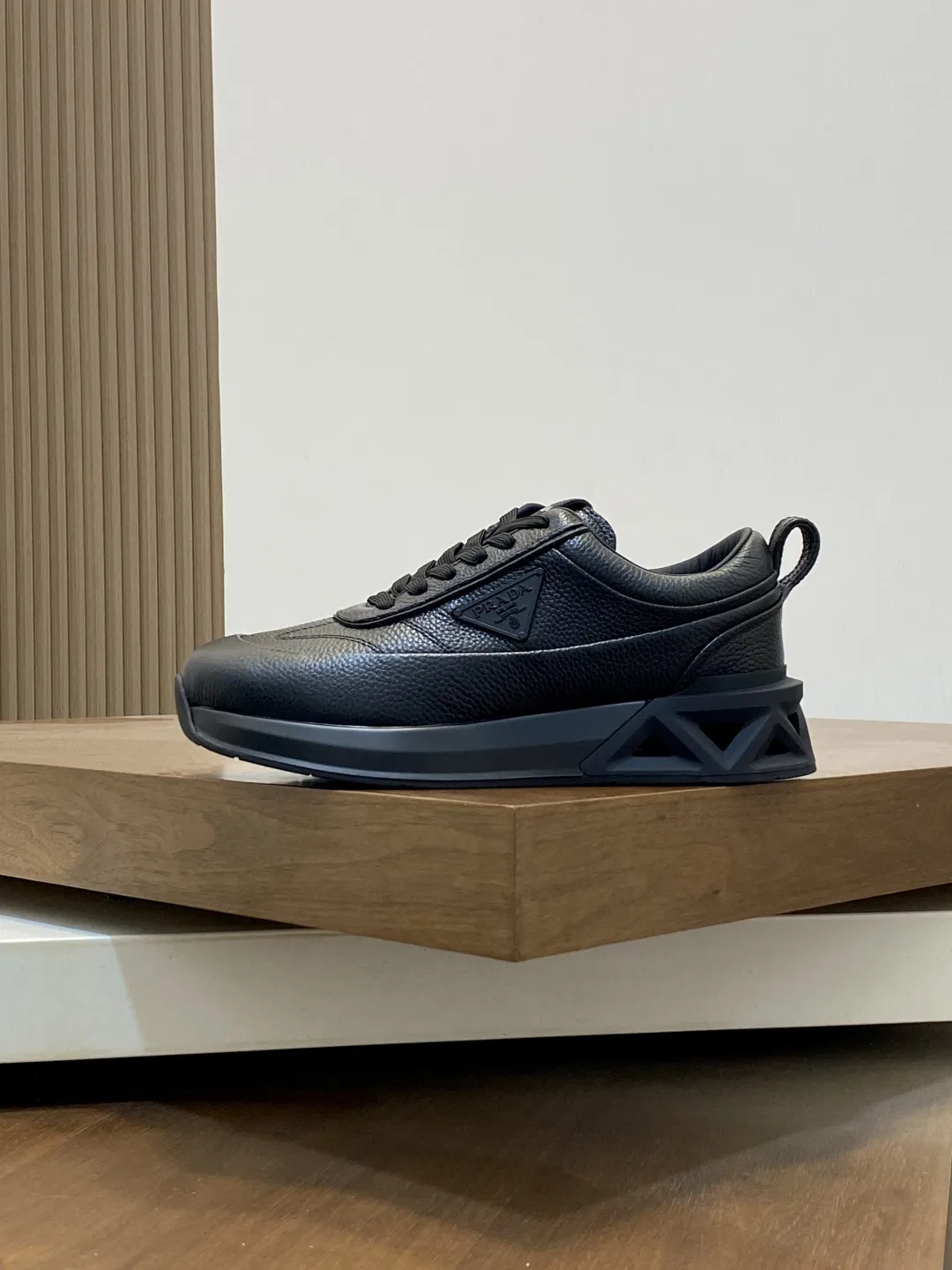 💰390 Prada/普拉达 男士新款皮面拼接运动鞋 这款运动鞋呈现现代版型，以利落线条与流畅细节重新演绎品牌典藏款型。鞋履采用小牛皮革和科技织物打造，外侧饰有三角金属徽标，后跟亮色TPU装饰，内里后跟加长加衬设计，穿着更舒适，鞋舌饰有丝印徽标，搭配后跟镂空橡胶厚底，全牛皮内里标配徽标牛皮垫脚，上脚增高舒适、百搭耐看！配全套原包装！ 码数：39-40-41-42-43-44 标准皮鞋尺码（45可定做不支持退换）