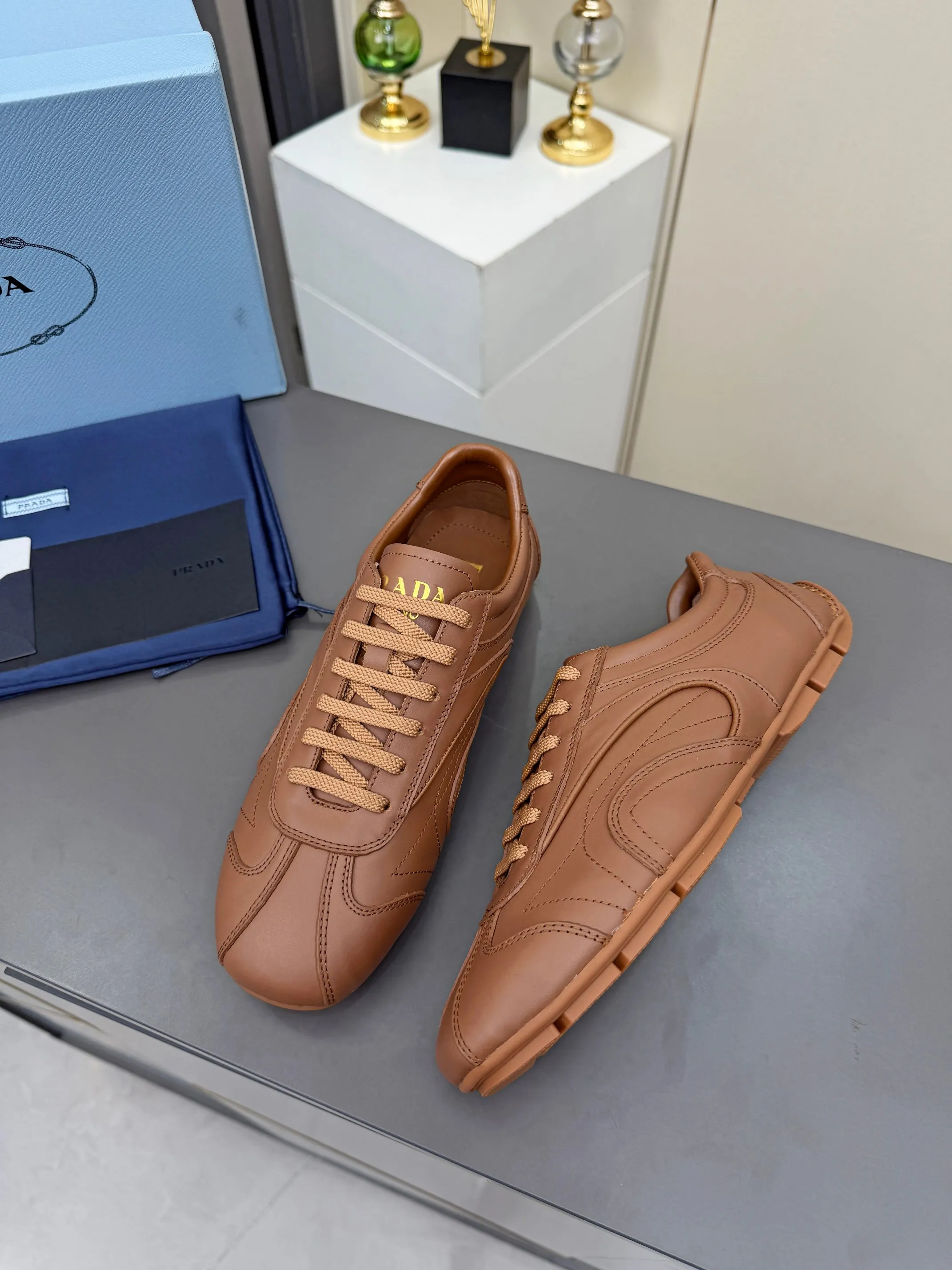 实价不让利P300！普拉达&middot;PRADA🔥2026最新款休闲德训鞋⛳️原版1比1开发，复古时髦前卫的设计，让整双鞋轻便舒适，皮与高丝光牛绒的设计更是简洁大方，搭配古沙滩凉鞋造型，每一个元素都踩在时髦点上🤗 ✦面料：进口头层牛皮 ✦内里：羊皮内里 ✦大底：原版1:1开双色生胶底 ✦码数：女码 35--40， ✦码数：男码 39--44， ✦码数：可以定做女41 女42 男45