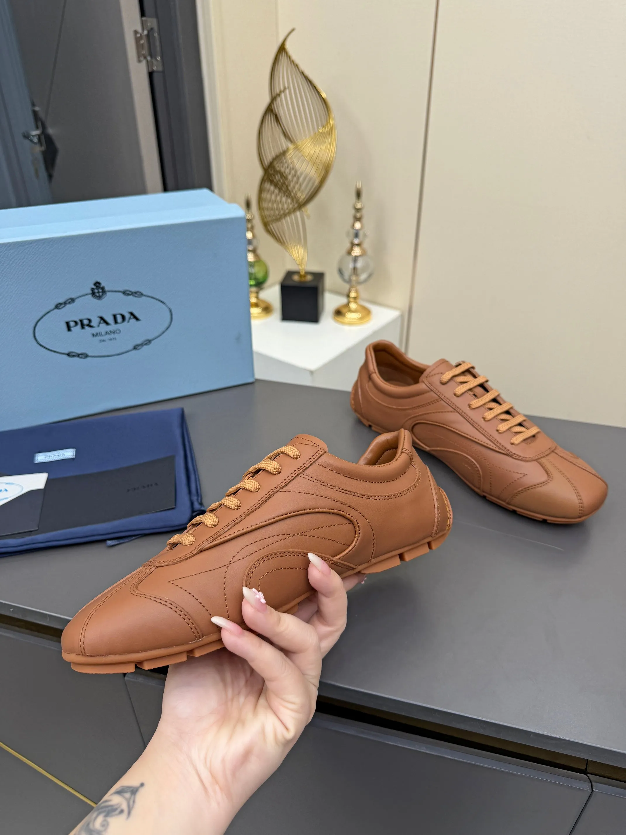 实价不让利P300！普拉达&middot;PRADA🔥2026最新款休闲德训鞋⛳️原版1比1开发，复古时髦前卫的设计，让整双鞋轻便舒适，皮与高丝光牛绒的设计更是简洁大方，搭配古沙滩凉鞋造型，每一个元素都踩在时髦点上🤗 ✦面料：进口头层牛皮 ✦内里：羊皮内里 ✦大底：原版1:1开双色生胶底 ✦码数：女码 35--40， ✦码数：男码 39--44， ✦码数：可以定做女41 女42 男45
