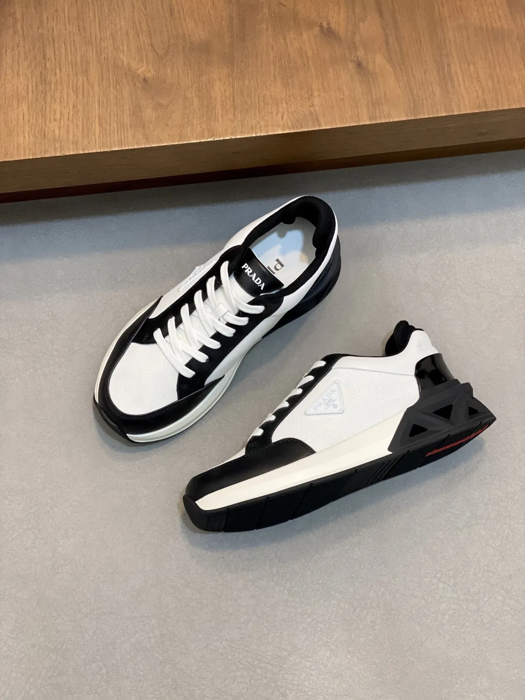 💰360 Prada/普拉达 男士新款网面拼接运动鞋 这款运动鞋呈现现代版型，以利落线条与流畅细节重新演绎品牌典藏款型。鞋履采用小牛皮革和科技织物打造，外侧饰有三角金属徽标，后跟亮色TPU装饰，内里后跟加长加衬设计，穿着更舒适，鞋舌饰有丝印徽标，搭配后跟镂空橡胶厚底，全牛皮内里标配徽标牛皮垫脚，上脚增高舒适、百搭耐看！配全套原包装！ 码数：39-40-41-42-43-44 标准皮鞋尺码（45可定做不支持退换）