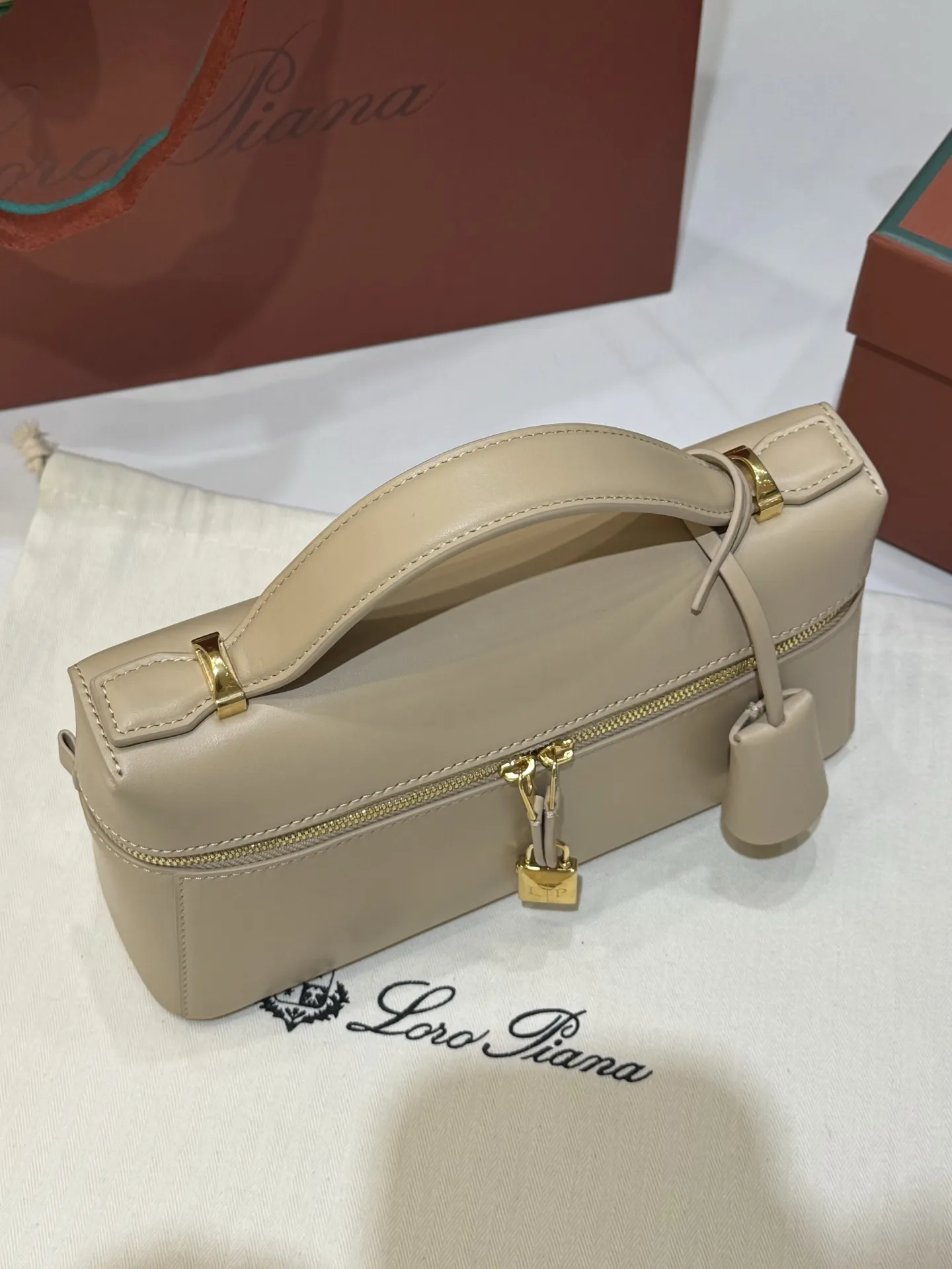 💰600 Extra Bag23手袋【平纹浅乳香】 采用Saddle Leather牛皮革材质精心制作,饰以繁复精致的明迹缝线,既可手提,亦可斜挎。双拉链开合处悬挂着LoroPiana的标志性挂饰,并搭配精致的皮革钥匙扣,可拆卸可调节肩带 双向拉链开合,饰有挂饰 内部皮革卡槽 皮革钥匙扣 绒面革衬里 金属色配件尺寸:23x12x 厘米手柄高度:5厘米 肩带长度:46-58厘米