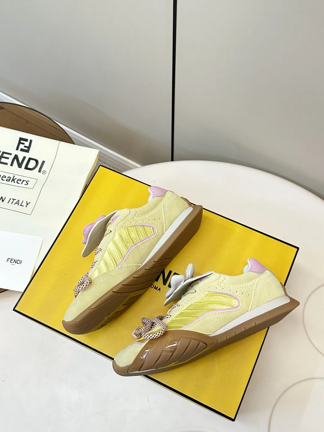 ​​FENDI 2026SS限量运动鞋​​ P310 💛FENDI 2026SS限量运动鞋，意大利制造，麂皮+织物拼接，浅黄主色配粉紫细节，清新又时髦✨。鞋带是品牌标志性织带，辨识度超高！ TPU橡胶鞋底抓地力强，日常穿搭或轻运动都OK。鞋舌&鞋侧有FENDI Logo，限量发售，收藏价值满分，超适合追求个性和品质的你！ 鞋面：麂皮+织物拼接 内里：羊皮 码数：35-40
