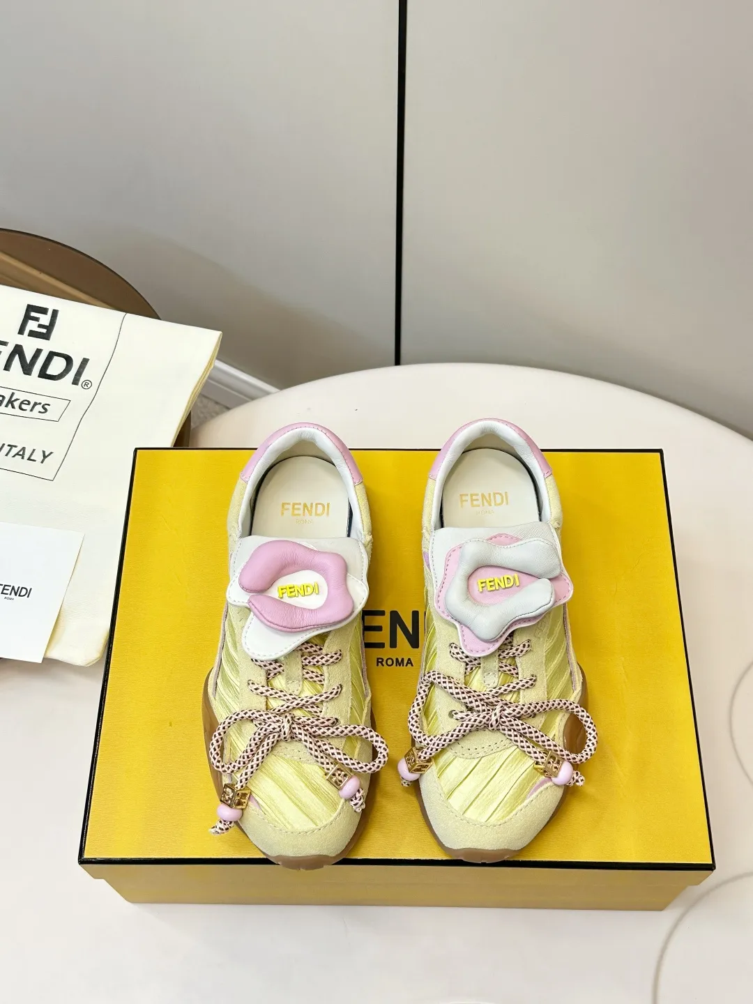 ​​FENDI 2026SS限量运动鞋​​ P310 💛FENDI 2026SS限量运动鞋，意大利制造，麂皮+织物拼接，浅黄主色配粉紫细节，清新又时髦✨。鞋带是品牌标志性织带，辨识度超高！ TPU橡胶鞋底抓地力强，日常穿搭或轻运动都OK。鞋舌&鞋侧有FENDI Logo，限量发售，收藏价值满分，超适合追求个性和品质的你！ 鞋面：麂皮+织物拼接 内里：羊皮 码数：35-40