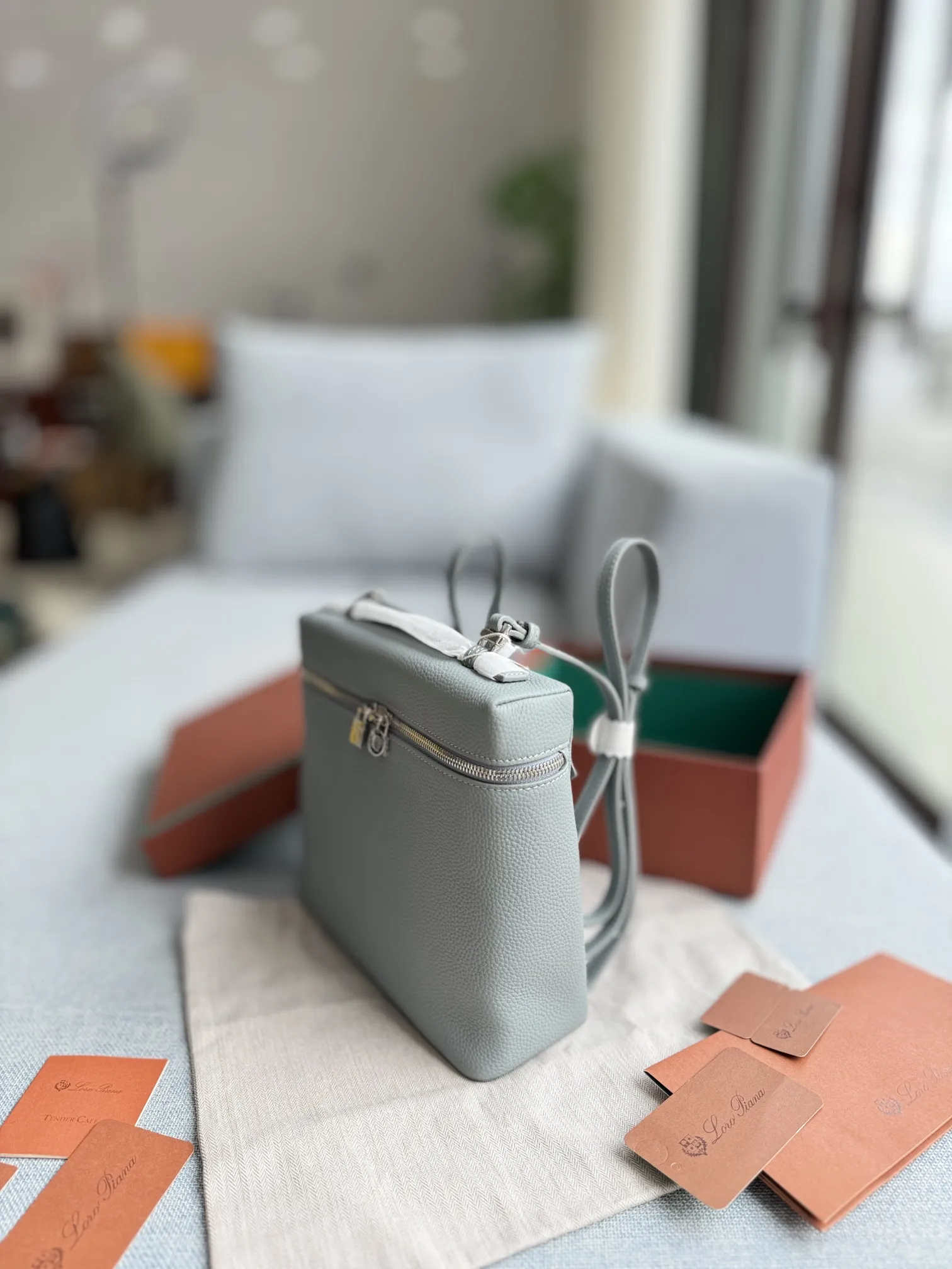 P215 配盒🎀 size:23×21 Loro Piana ExtraPocket L23.5 豆腐包 双肩包 造型实在太可爱了! 一如既往的极简风格 新出珍珠灰特别有质感! 一眼就被这款米色手提双肩包吸引了 它静静地躺在木质桌面上 宛如一位等待被发现的优雅女子。