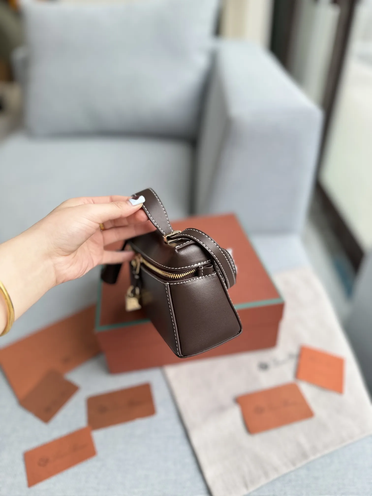 小号P205 配盒🎀 size：19.5&times;10.5 Loro Piana Extra Bag L27 饭盒包 单肩斜挎手提包 手袋包 这个包型以几何造型展示了精美与优雅风范复古手袋的魅力 加上细心雕琢的细节锋线饰边凸显出简洁干练的线条 为新手袋增添了现代的品味! 皮质采用了牛皮制作而成具有细腻而饱满的纹理感金属点缀 独特精致