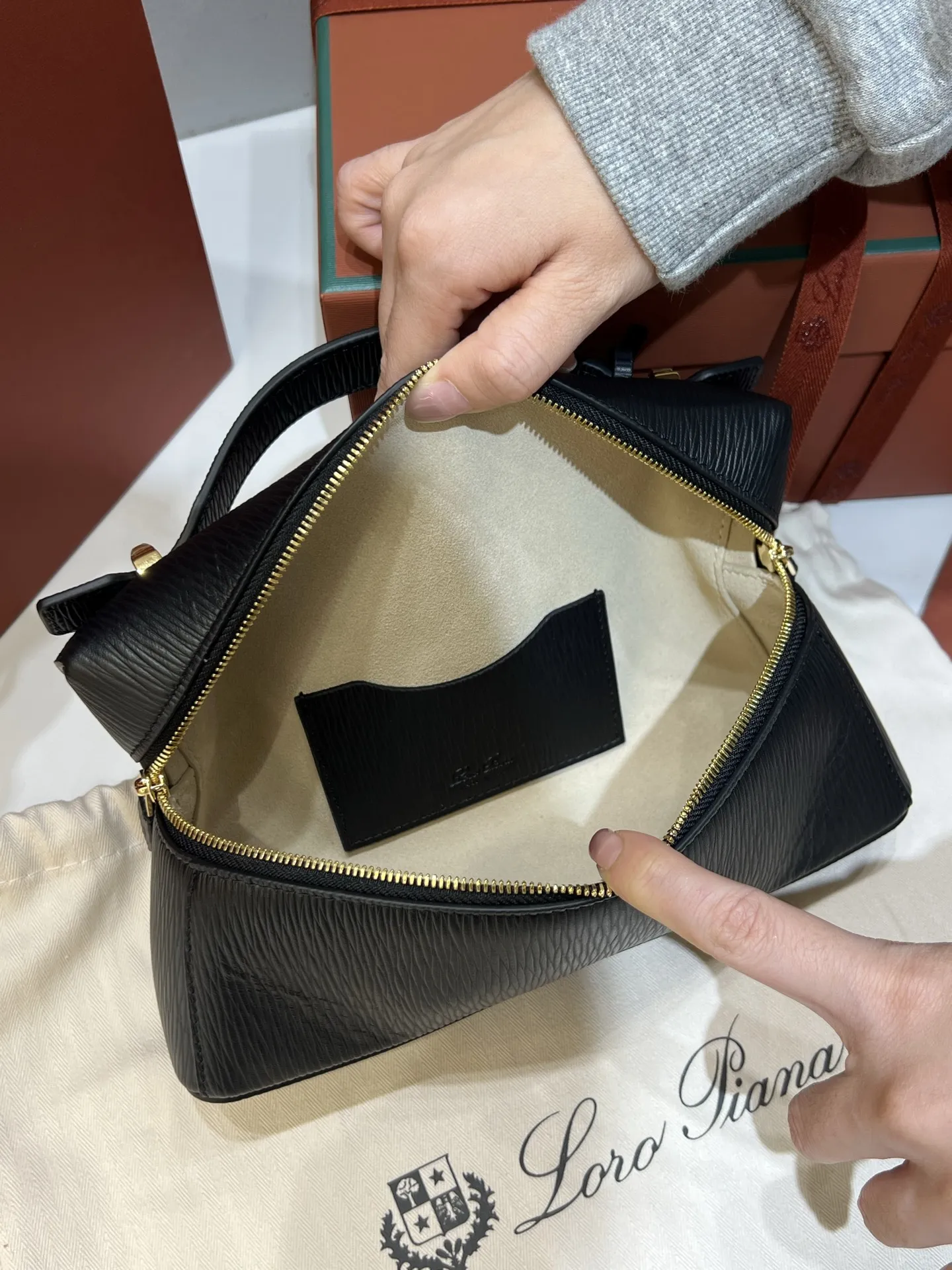 💰600 Extra Bag23手袋【水波纹黑色】 采用Saddle Leather牛皮革材质精心制作,饰以繁复精致的明迹缝线,既可手提,亦可斜挎。双拉链开合处悬挂着LoroPiana的标志性挂饰,并搭配精致的皮革钥匙扣,可拆卸可调节肩带 双向拉链开合,饰有挂饰 内部皮革卡槽 皮革钥匙扣 绒面革衬里 金属色配件尺寸:23x12x 厘米手柄高度:5厘米 肩带长度:46-58厘米