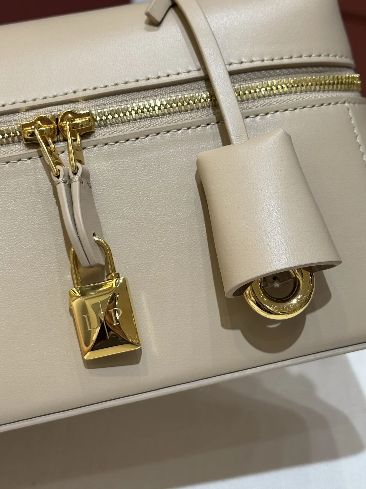 💰600 Extra Bag23手袋【平纹浅乳香】 采用Saddle Leather牛皮革材质精心制作,饰以繁复精致的明迹缝线,既可手提,亦可斜挎。双拉链开合处悬挂着LoroPiana的标志性挂饰,并搭配精致的皮革钥匙扣,可拆卸可调节肩带 双向拉链开合,饰有挂饰 内部皮革卡槽 皮革钥匙扣 绒面革衬里 金属色配件尺寸:23x12x 厘米手柄高度:5厘米 肩带长度:46-58厘米