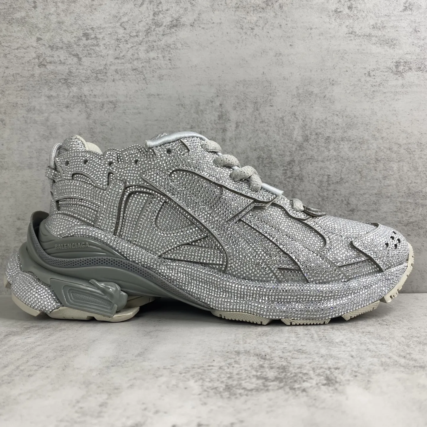 💰550🔥新款上架🔥BALENCIAGA Runner Sneaker 满钻 巴黎世家七代慢跑系列低帮复古野跑潮流运动鞋老爹鞋 尼龙和网布材质 磨损效果 鞋头边缘印有尺码 背面浮印尺码 外侧印有跑者徽标 鞋舌刺绣 Balenciaga 品牌标识 鞋跟背面 Balenciaga品牌标识 材质采用65%聚氨酯、35%聚酯纤维 全新 Runner 鞋型轮廓借鉴于 2000 年初的复古线条 搭载大网眼面料制成鞋面基础,由粉色、白色尼龍与橡胶质地覆盖鞋面诠释线条感 尤其是鞋领处与鞋带孔眼条更是采用不规则做旧技术将内容物泡棉随机露出 尺码:35 36 37 38 39 40 41 42 43 44 45