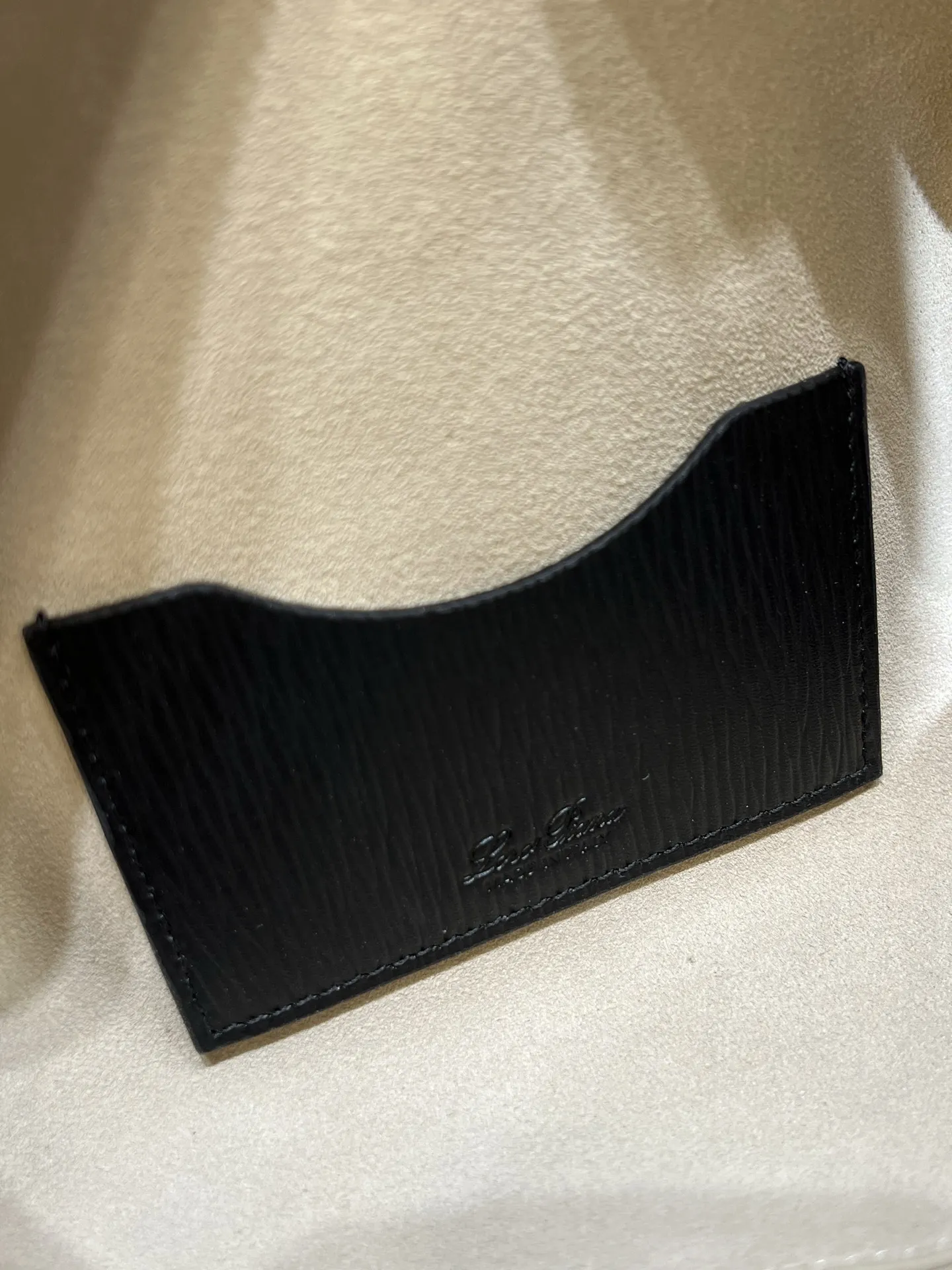 💰600 Extra Bag23手袋【水波纹黑色】 采用Saddle Leather牛皮革材质精心制作，饰以繁复精致的明迹缝线，既可手提，亦可斜挎。双拉链开合处悬挂着LoroPiana的标志性挂饰，并搭配精致的皮革钥匙扣，可拆卸可调节肩带 双向拉链开合，饰有挂饰 内部皮革卡槽 皮革钥匙扣 绒面革衬里 金属色配件尺寸：23x12x 厘米手柄高度：5厘米 肩带长度：46-58厘米