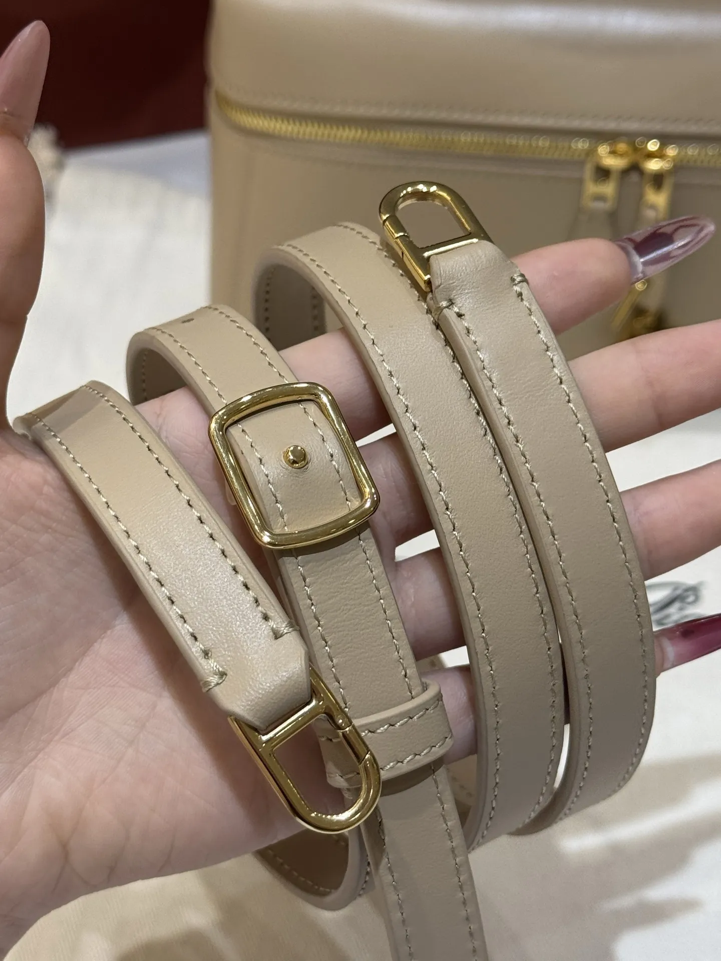 💰600 Extra Bag23手袋【平纹浅乳香】 采用Saddle Leather牛皮革材质精心制作,饰以繁复精致的明迹缝线,既可手提,亦可斜挎。双拉链开合处悬挂着LoroPiana的标志性挂饰,并搭配精致的皮革钥匙扣,可拆卸可调节肩带 双向拉链开合,饰有挂饰 内部皮革卡槽 皮革钥匙扣 绒面革衬里 金属色配件尺寸:23x12x 厘米手柄高度:5厘米 肩带长度:46-58厘米