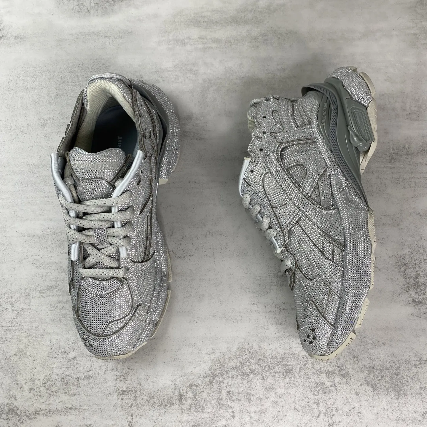 💰550🔥新款上架🔥BALENCIAGA Runner Sneaker 满钻 巴黎世家七代慢跑系列低帮复古野跑潮流运动鞋老爹鞋 尼龙和网布材质 磨损效果 鞋头边缘印有尺码 背面浮印尺码 外侧印有跑者徽标 鞋舌刺绣 Balenciaga 品牌标识 鞋跟背面 Balenciaga品牌标识 材质采用65%聚氨酯、35%聚酯纤维 全新 Runner 鞋型轮廓借鉴于 2000 年初的复古线条 搭载大网眼面料制成鞋面基础,由粉色、白色尼龍与橡胶质地覆盖鞋面诠释线条感 尤其是鞋领处与鞋带孔眼条更是采用不规则做旧技术将内容物泡棉随机露出 尺码:35 36 37 38 39 40 41 42 43 44 45