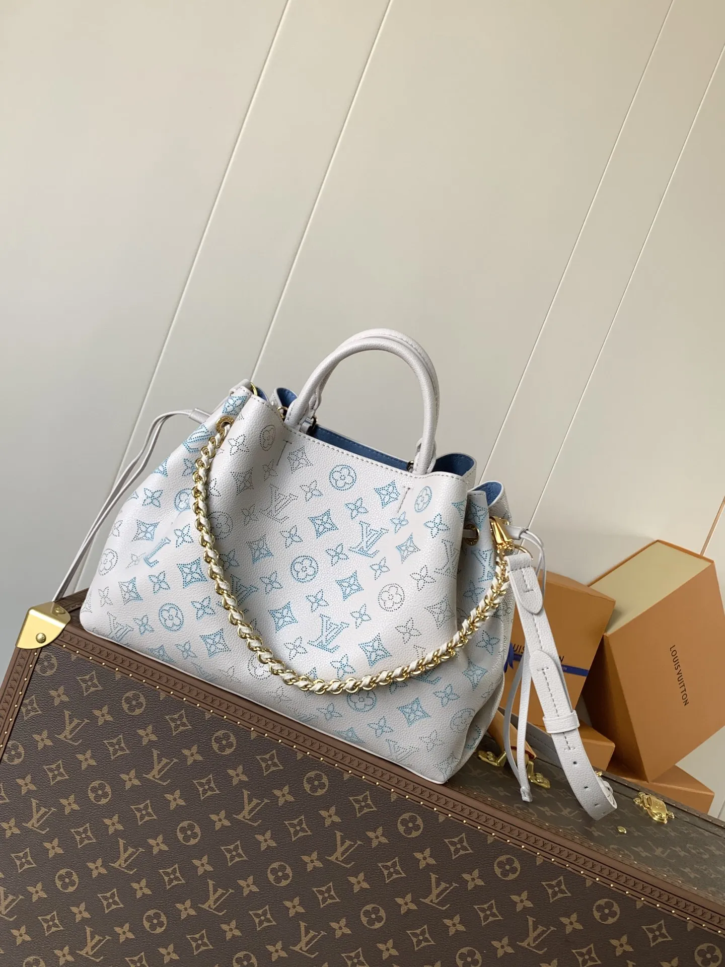 1:1Louis Vuitton Bella bucket bag in white Mahina perforated leather on a luxury trunk - xiashuluxe