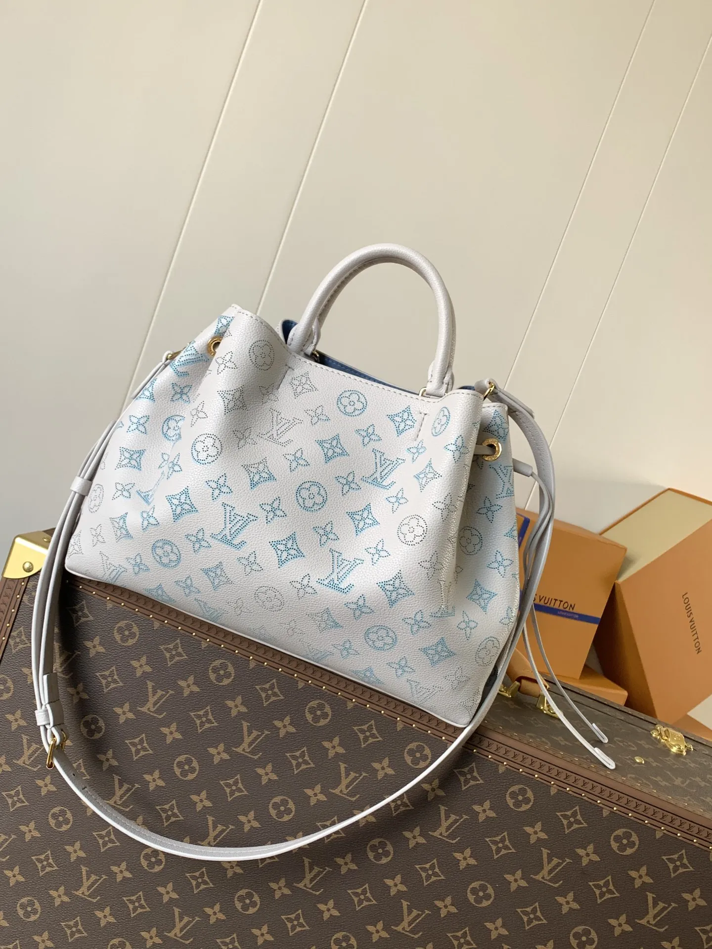 1:1Louis Vuitton Bella bucket bag in white Mahina perforated leather on a luxury trunk - xiashuluxe