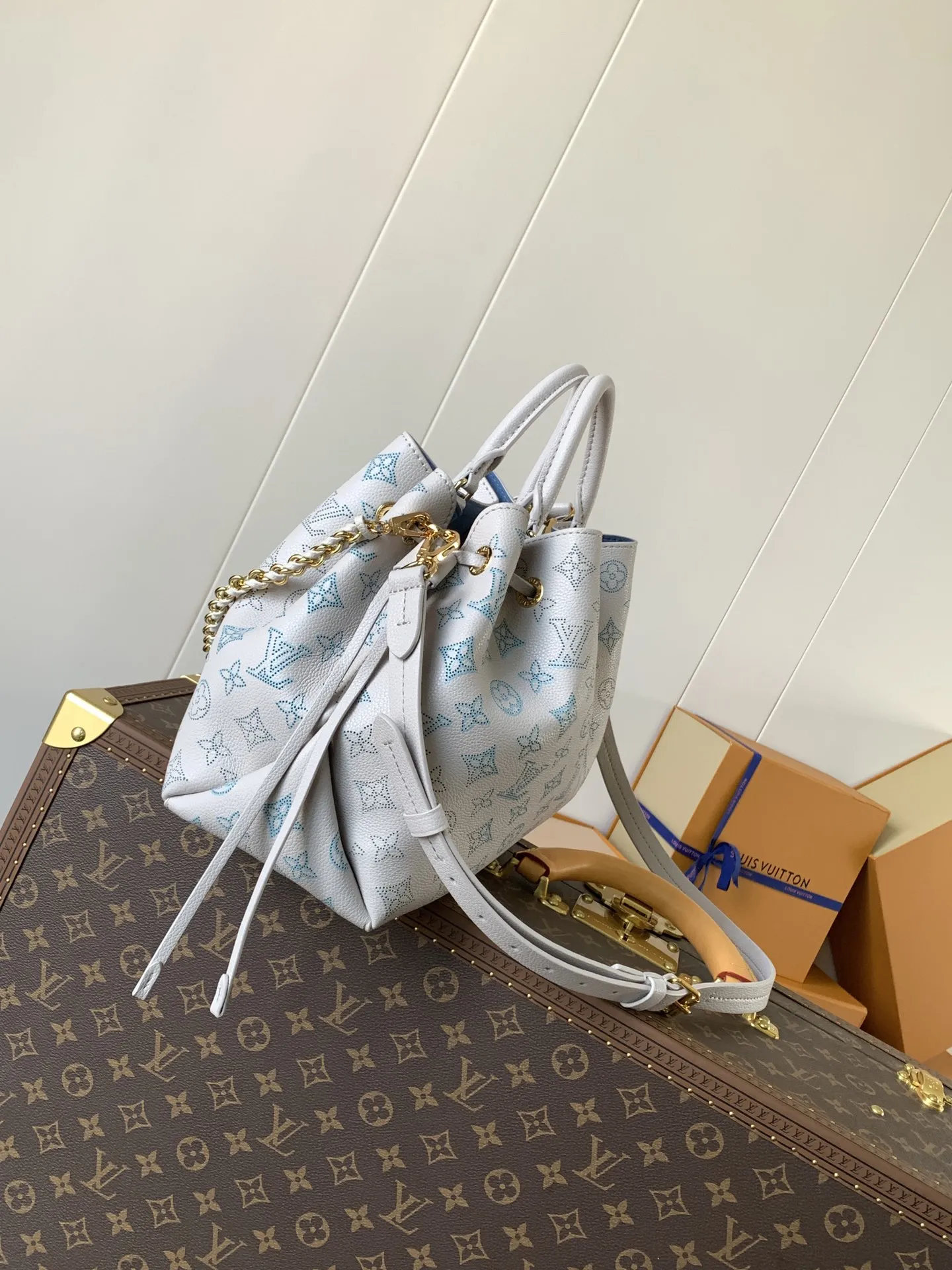 1:1Louis Vuitton Bella bucket bag in white Mahina perforated leather on a luxury trunk - xiashuluxe