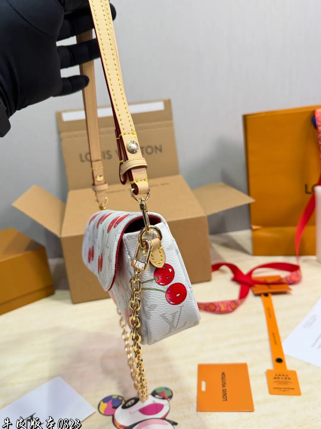 1:1Louis Vuitton Cherry Pochette Accessoires Monogram canvas bag with luxury packaging on table - xiashu