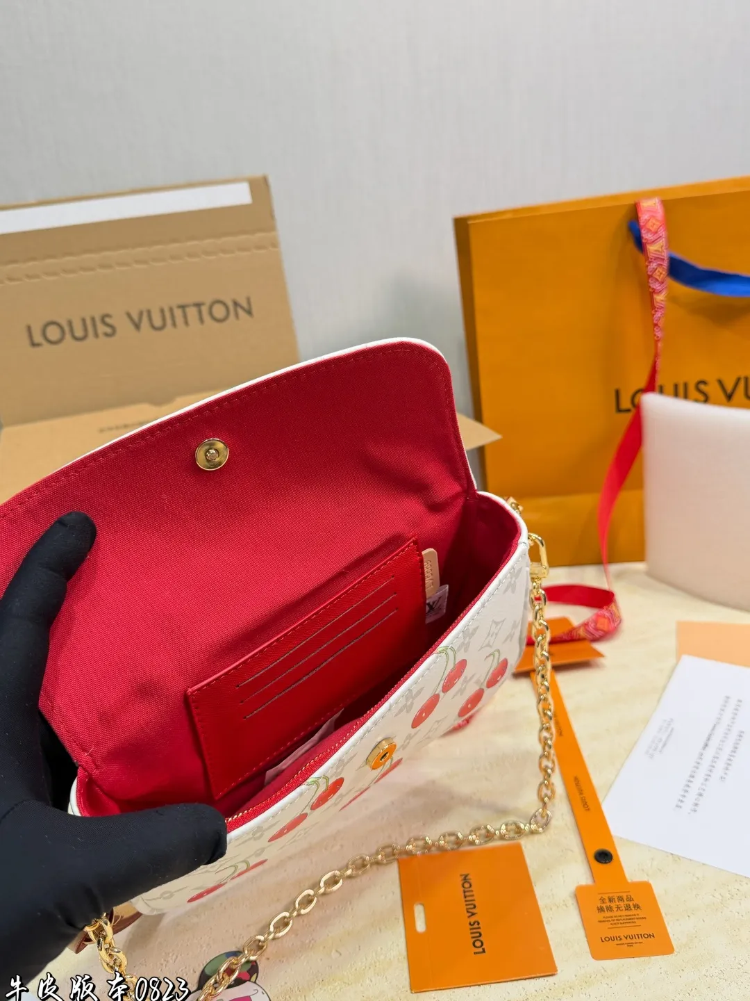 1:1Louis Vuitton Cherry Pochette Accessoires Monogram canvas bag with luxury packaging on table - xiashu9