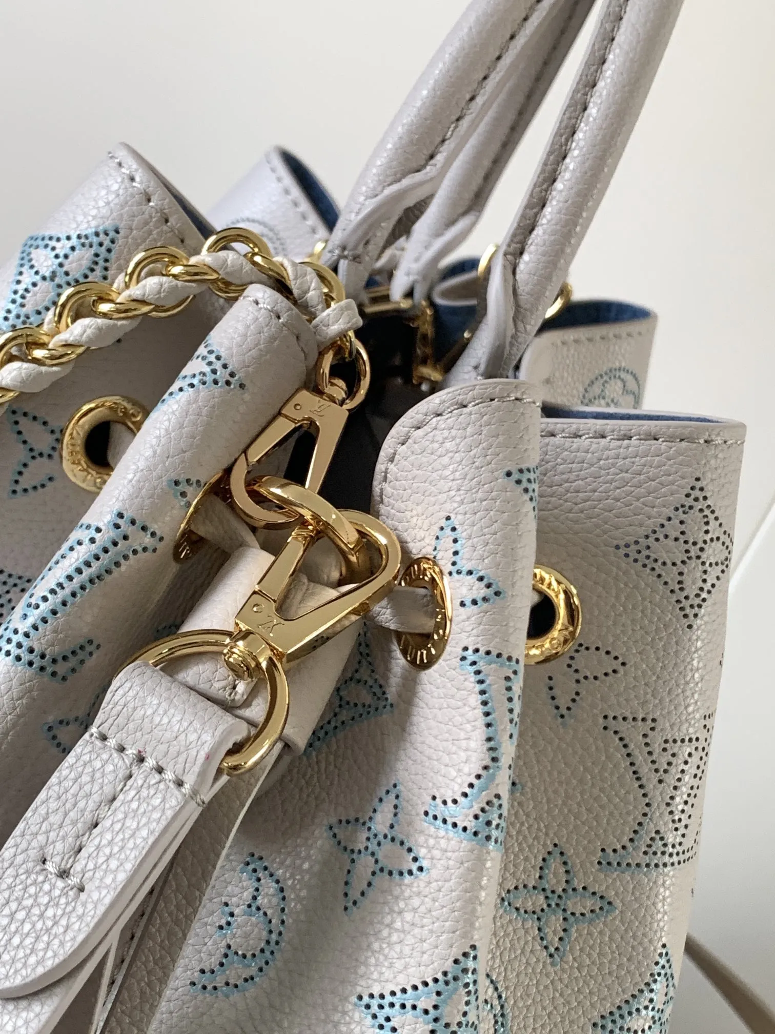 1:1Louis Vuitton Bella bucket bag in white Mahina perforated leather on a luxury trunk - xiashuluxe