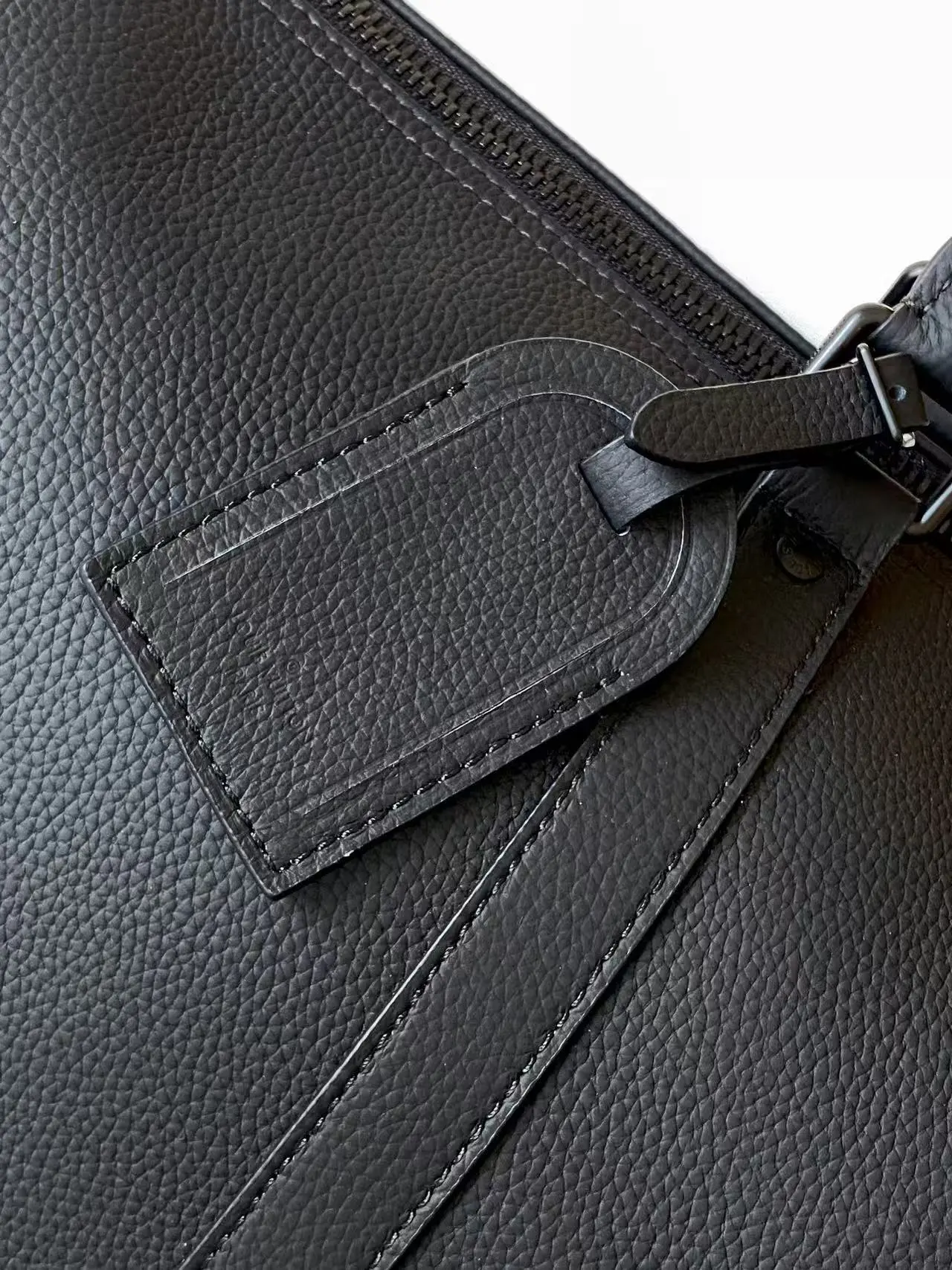 Louis Vuitton Keepall Bandoulière 1:1 Aerogram black leather travel bag on a white chair - xiashuluxe