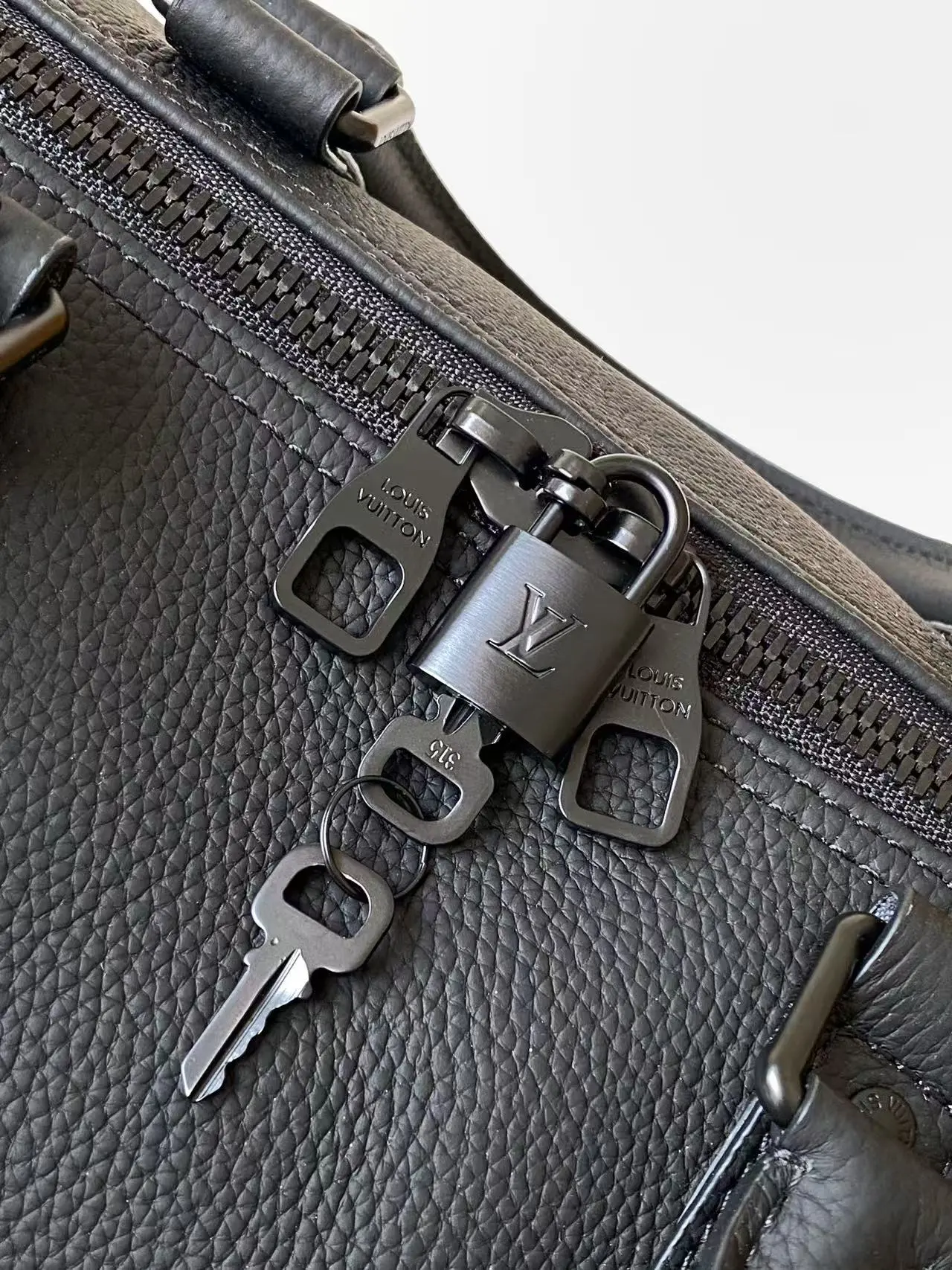 Louis Vuitton Keepall Bandouli&egrave;re 1:1 Aerogram black leather travel bag on a white chair - xiashuluxe