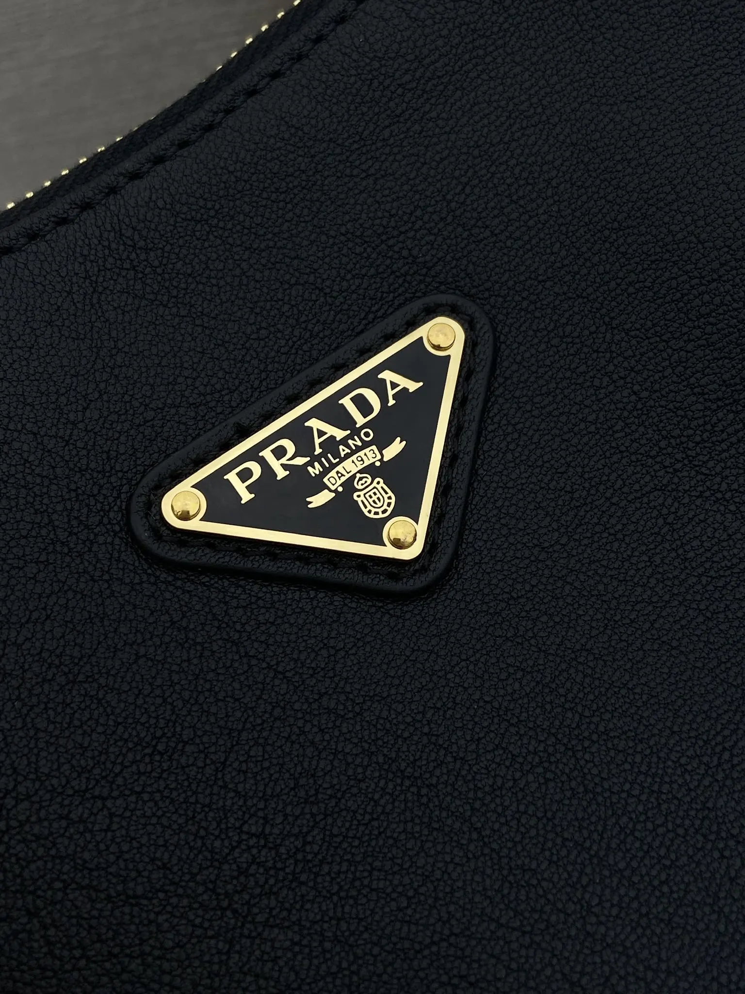 Prada 1:1 premium soft grained leather hobo bag in black with triangle logo and dual shoulder straps on display stand - xiashuluxe
