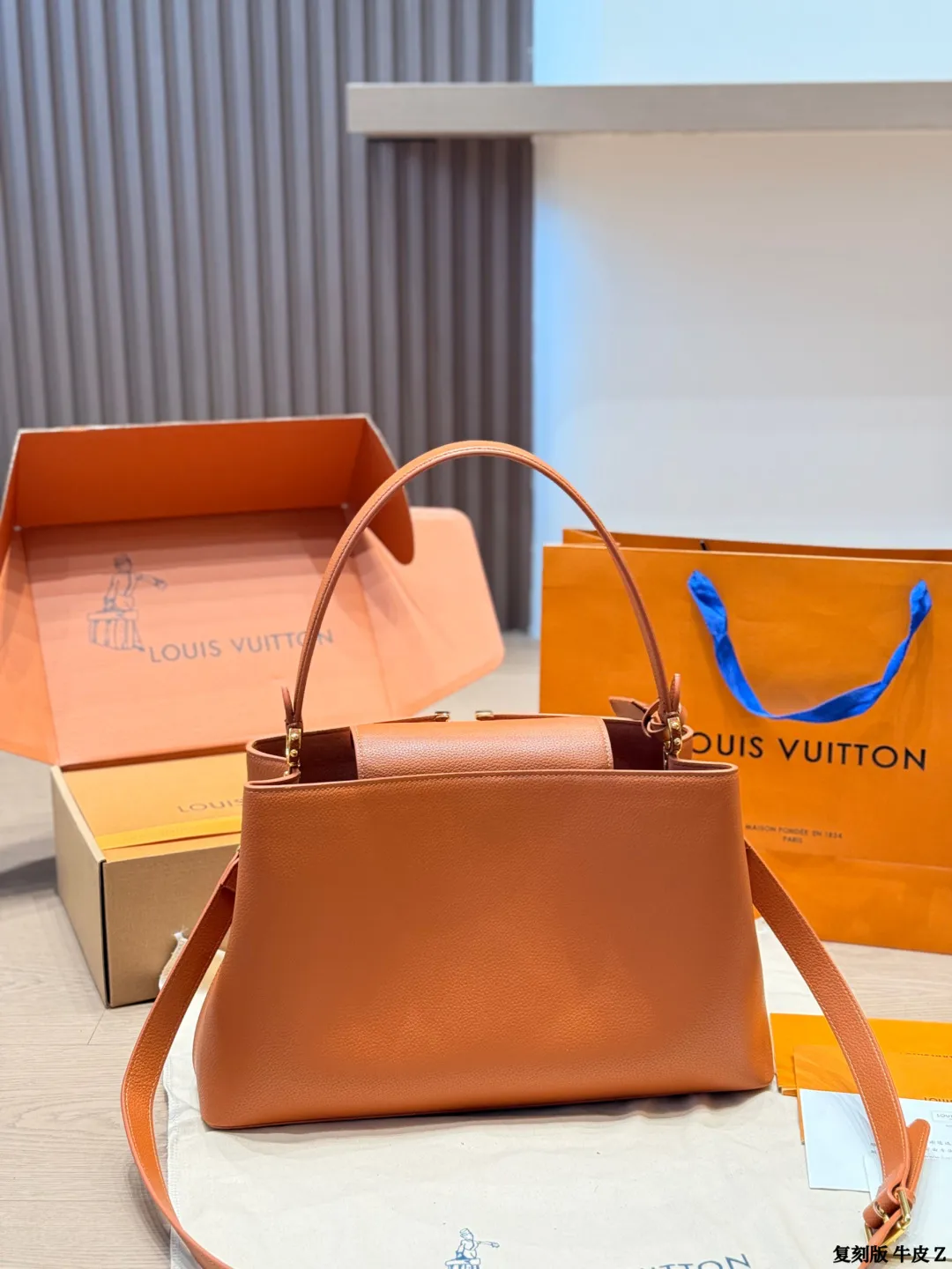 LV 1:1 premium Low Key Hobo bag in Cognac grained calfskin with gold-tone padlock and adjustable strap on display with boutique packaging - xiashuluxe
